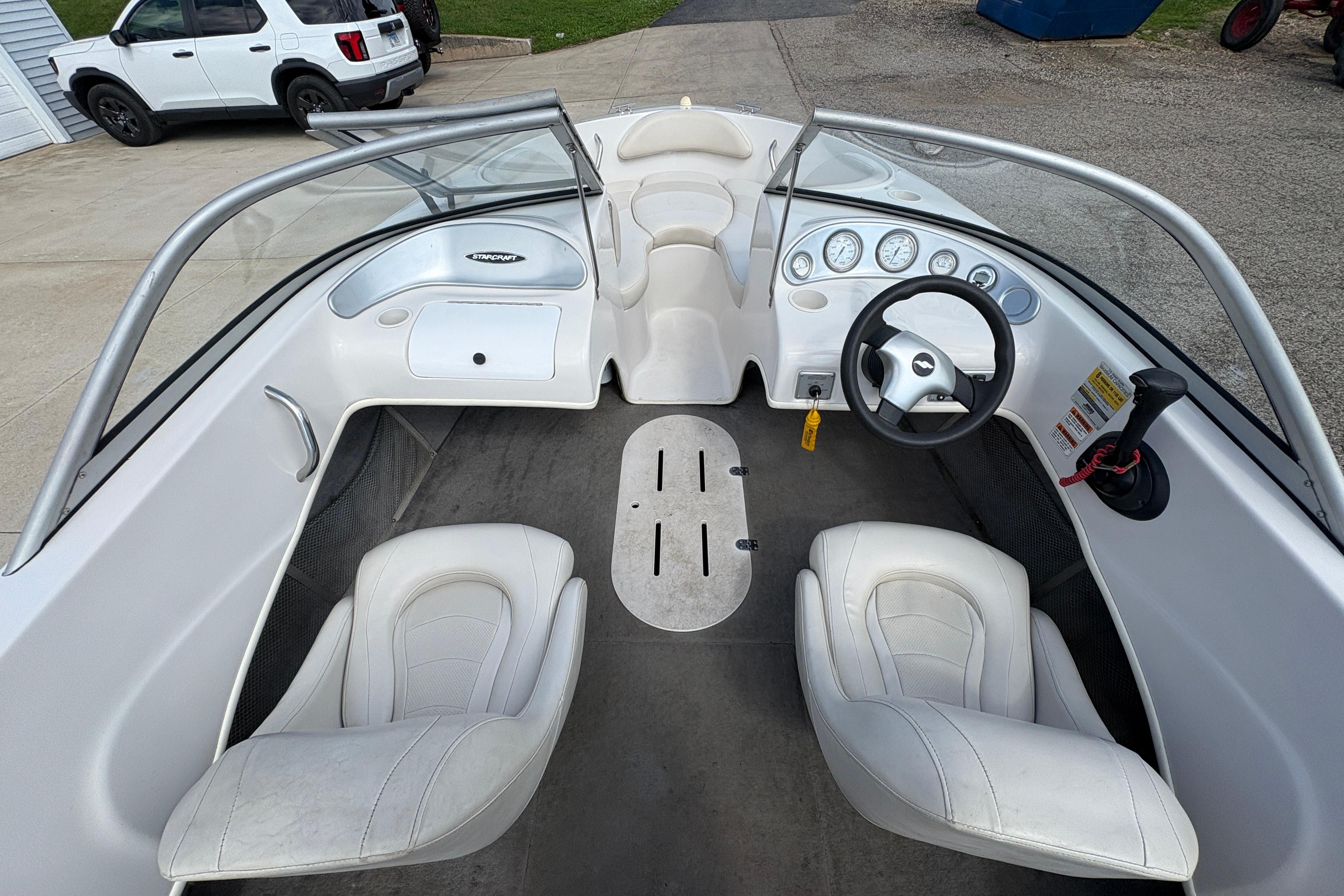 2005 Starcraft C-Star 1700 OB boat interior with white seating and dashboard controls.