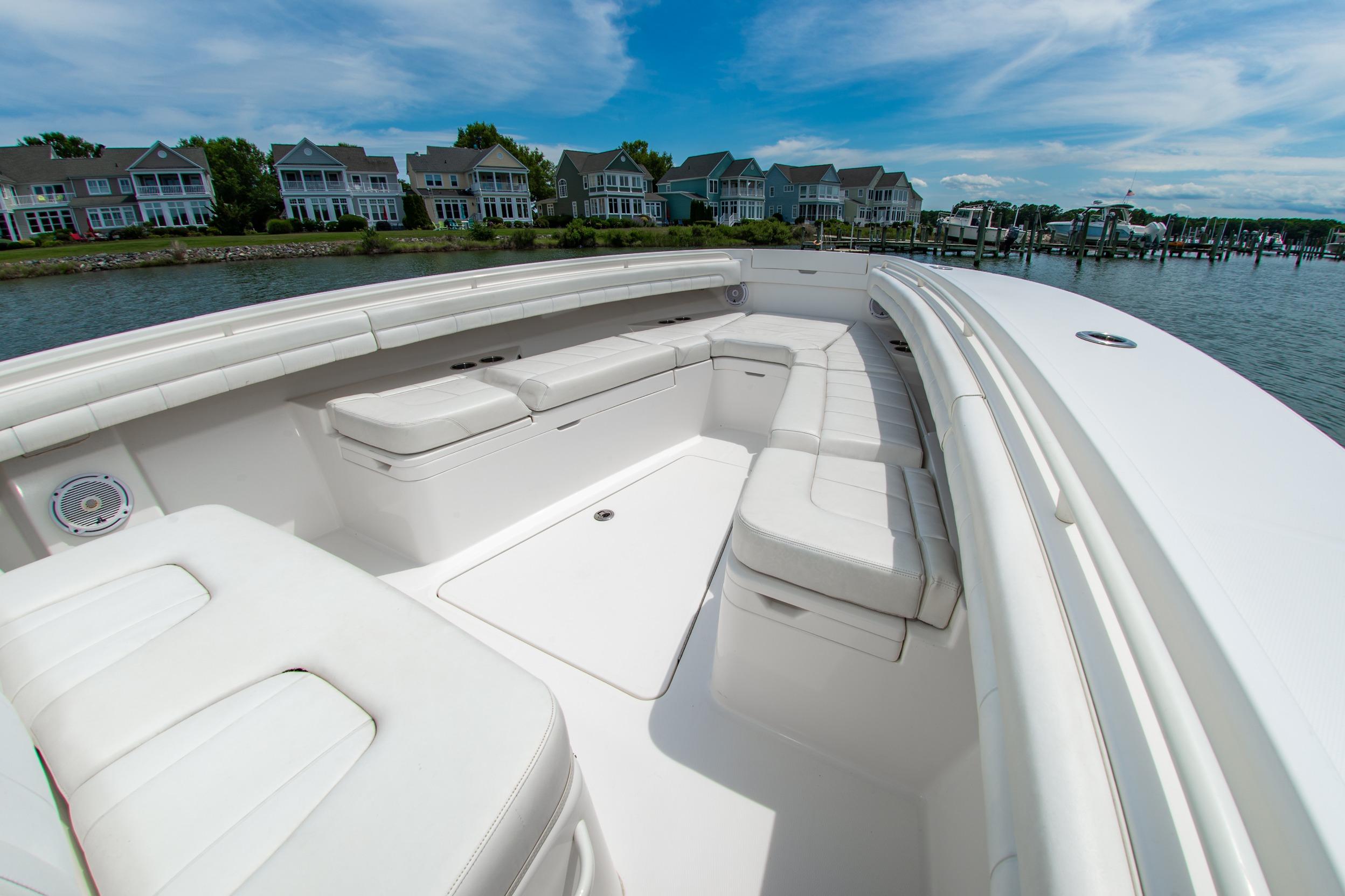 2019 Regulator 31 boat with spacious white seating, docked near waterfront homes.