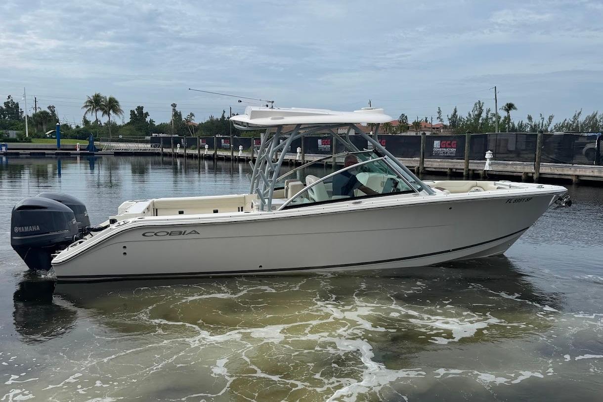 2020 Cobia 280 Dual Console boat on calm water, featuring Yamaha outboard engines.