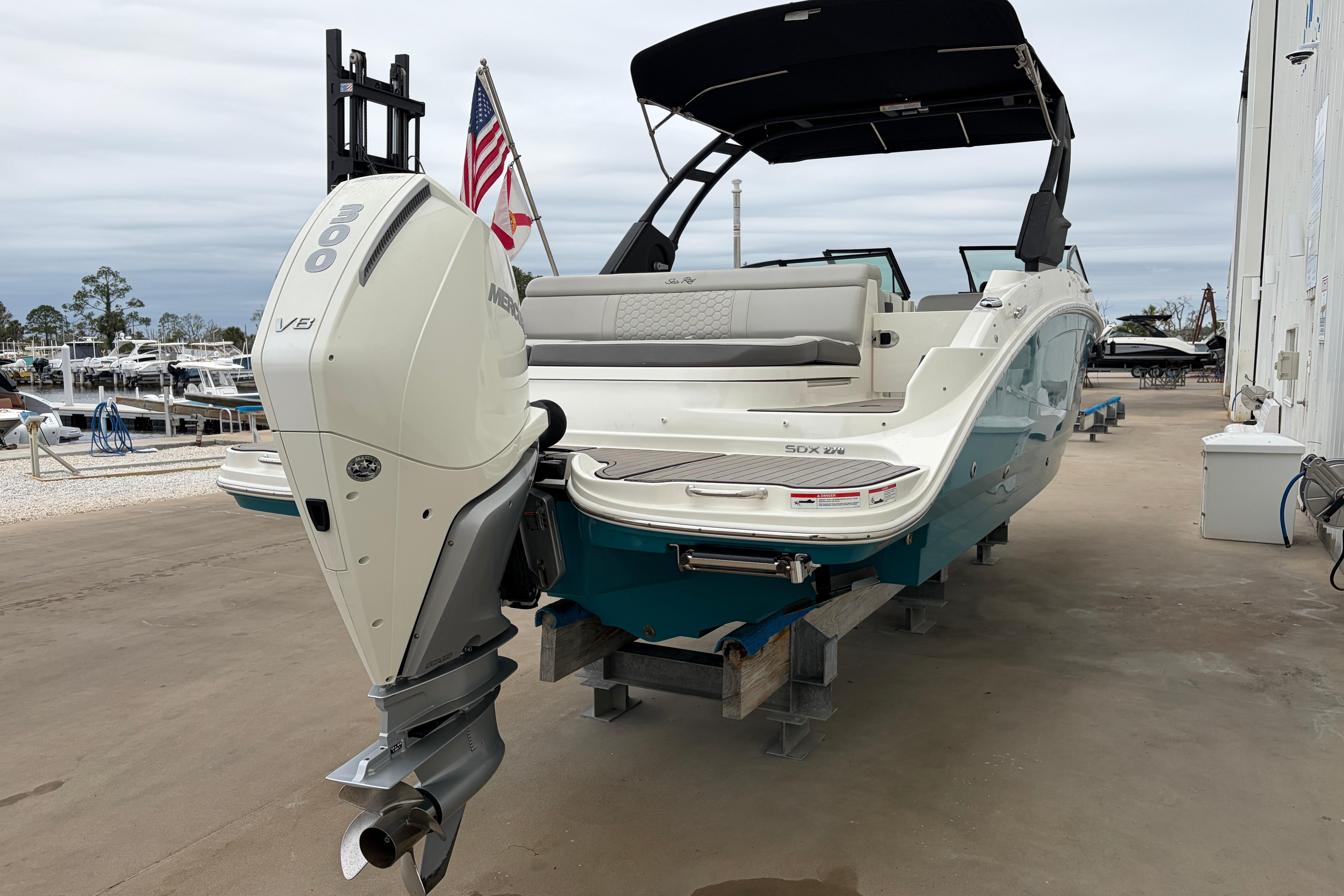 2024 Sea Ray SDX 270 Outboard boat with powerful engine, docked outdoors.