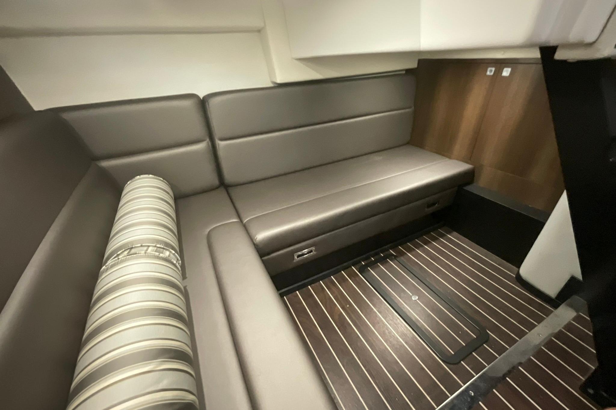 Interior of 2019 Monterey 335 Sport Yacht with sleek seating and wood flooring.