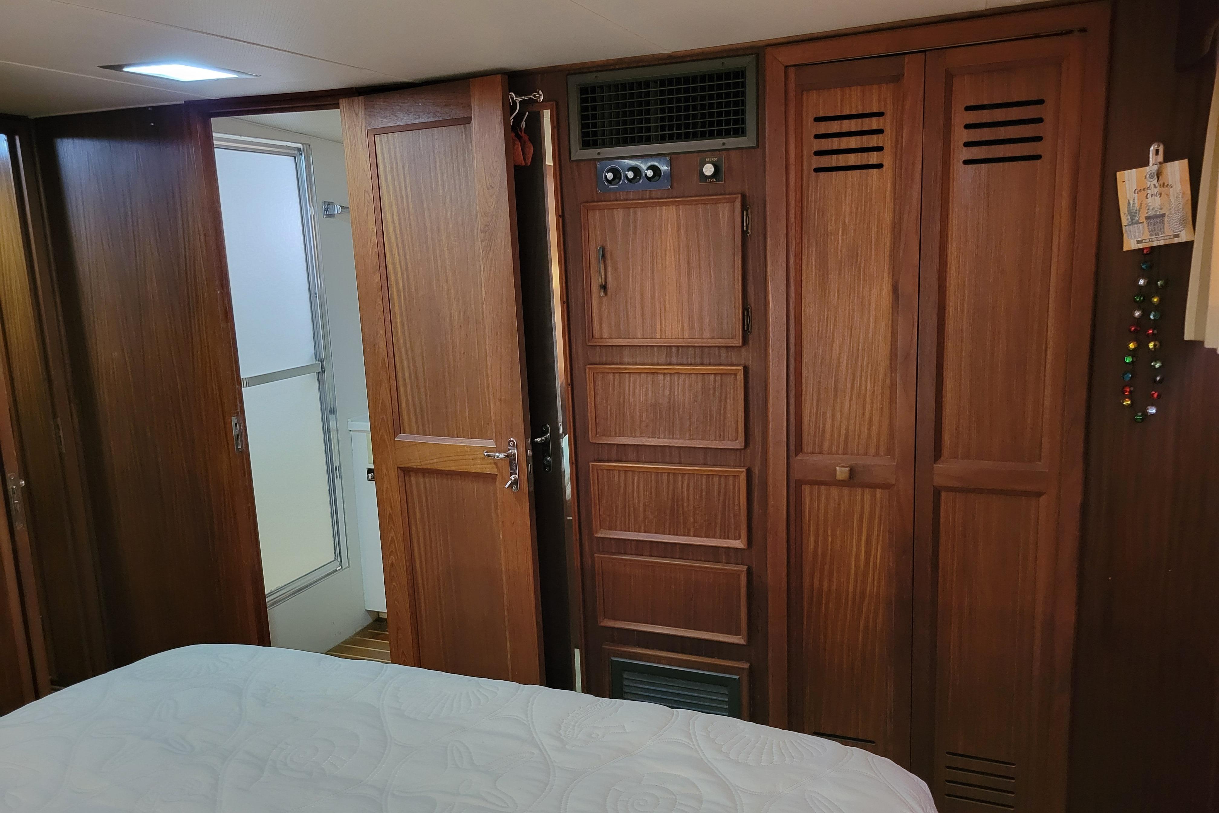 Interior of 1980 Hatteras 53 Yacht Fisherman with wooden cabinetry and open bathroom door.