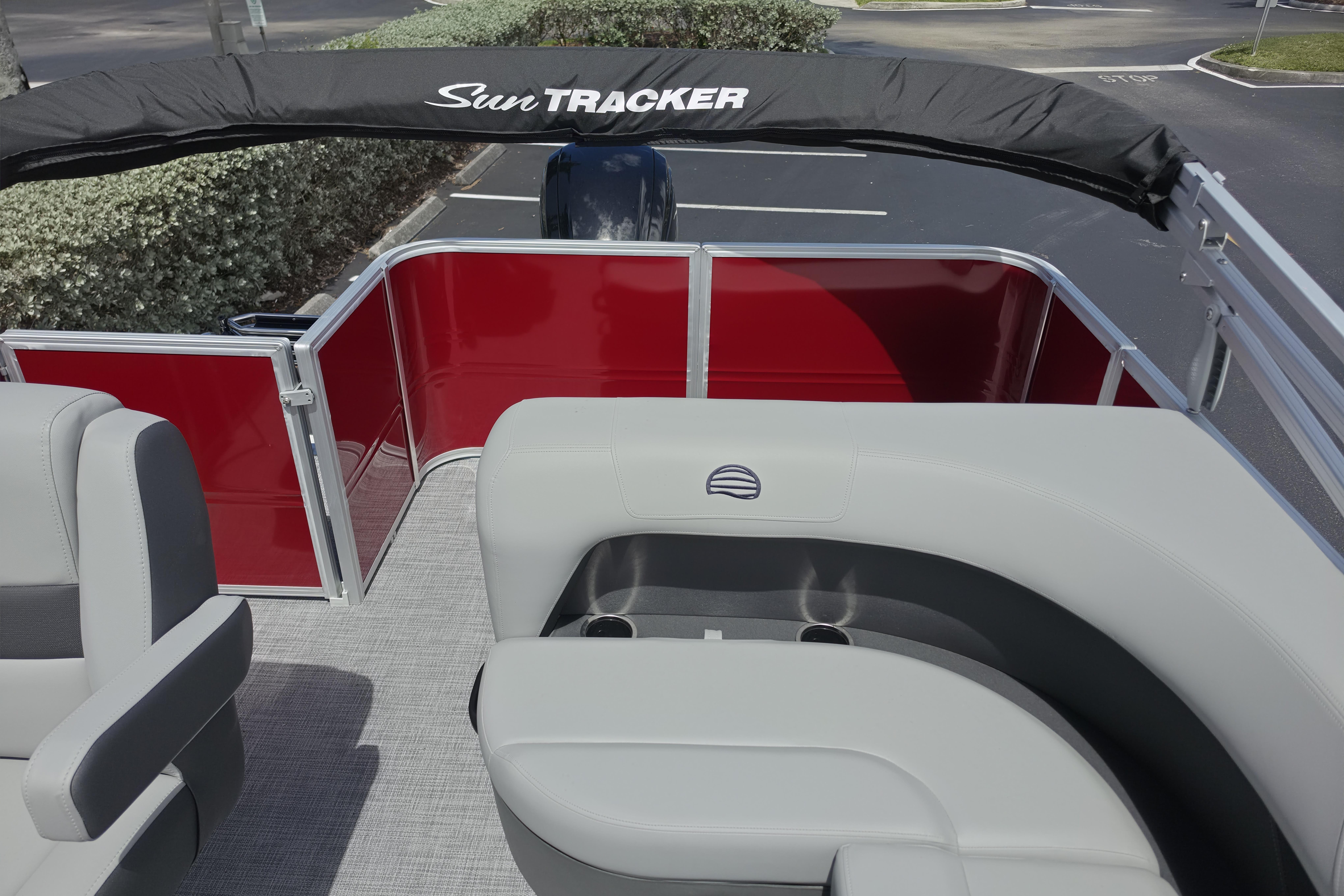 2026 Sun Tracker Party Barge 18 DLX interior with gray seating and red paneling.