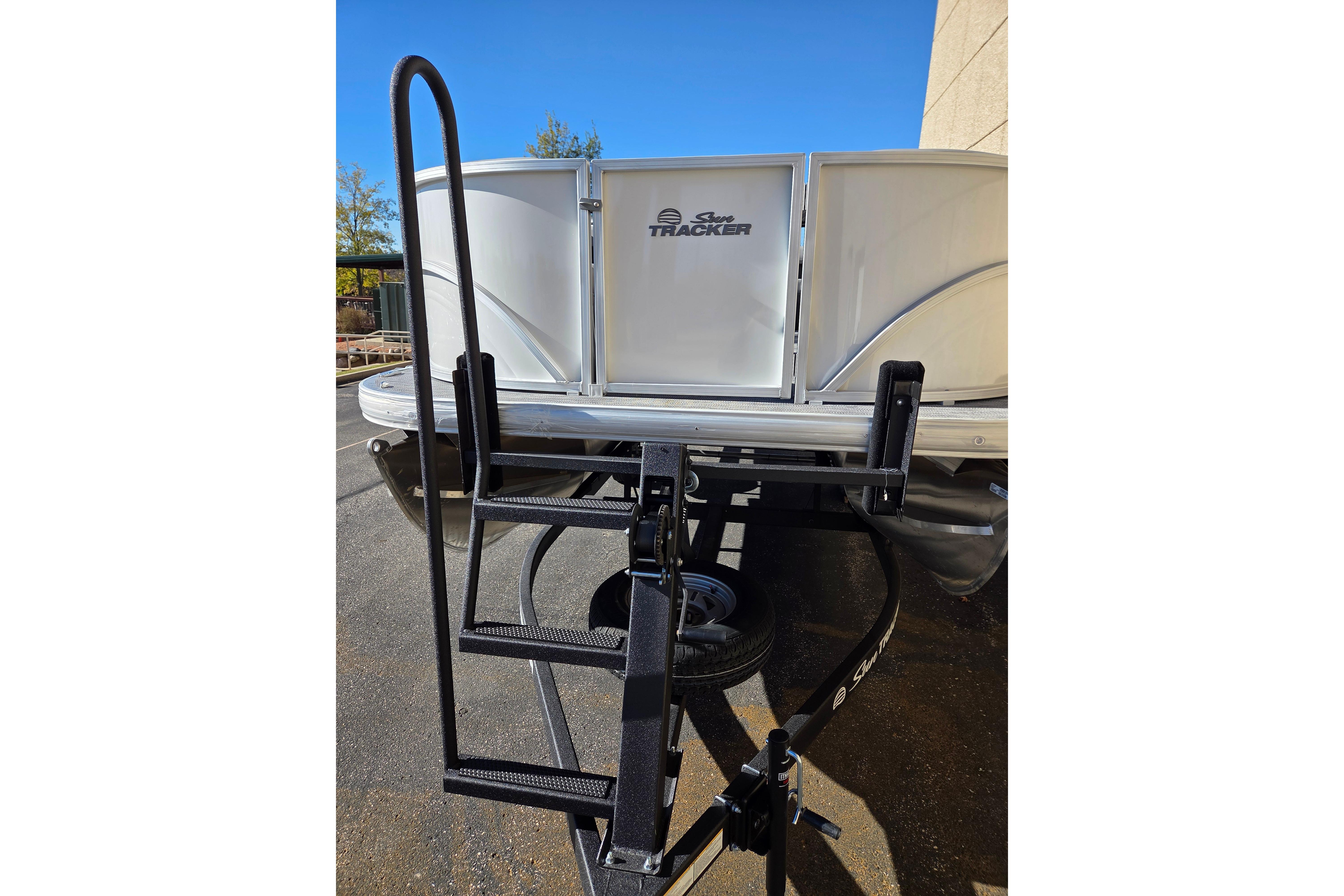 2026 Sun Tracker Party Barge 18 DLX on trailer, rear view with ladder.