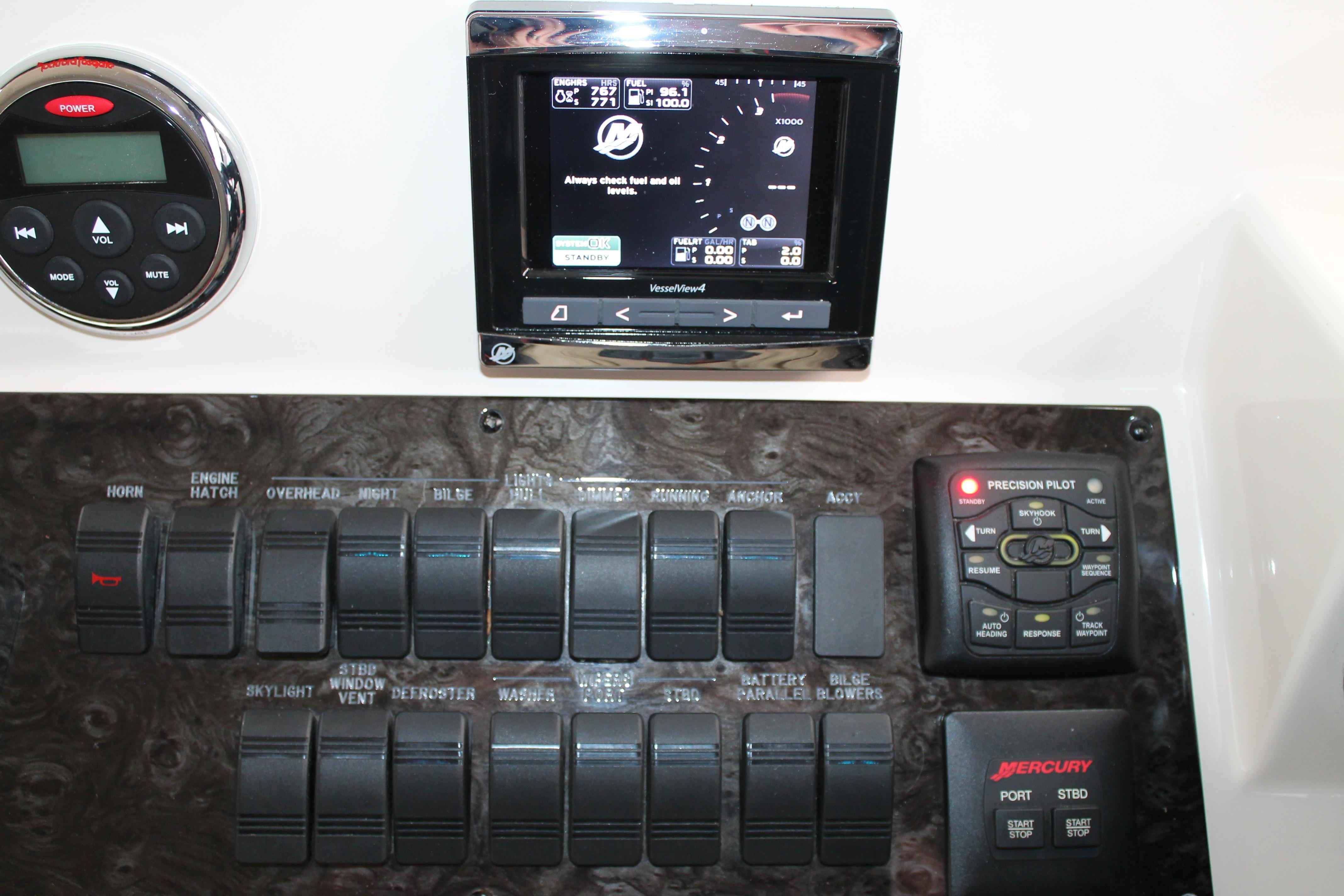 Control panel of a 2015 Sea Ray 470 Sundancer boat with various switches and displays.
