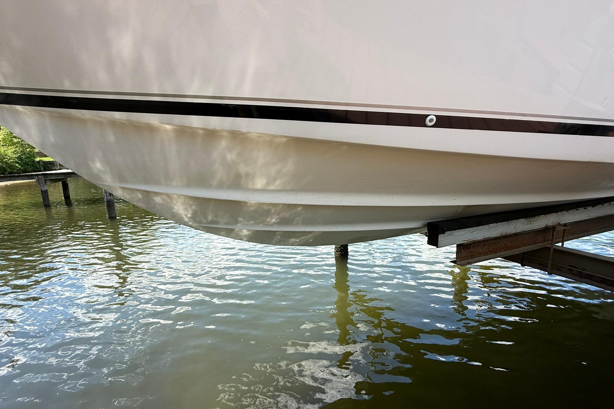 2003 Pursuit 2870 Walkaround boat hull above water on a lift.