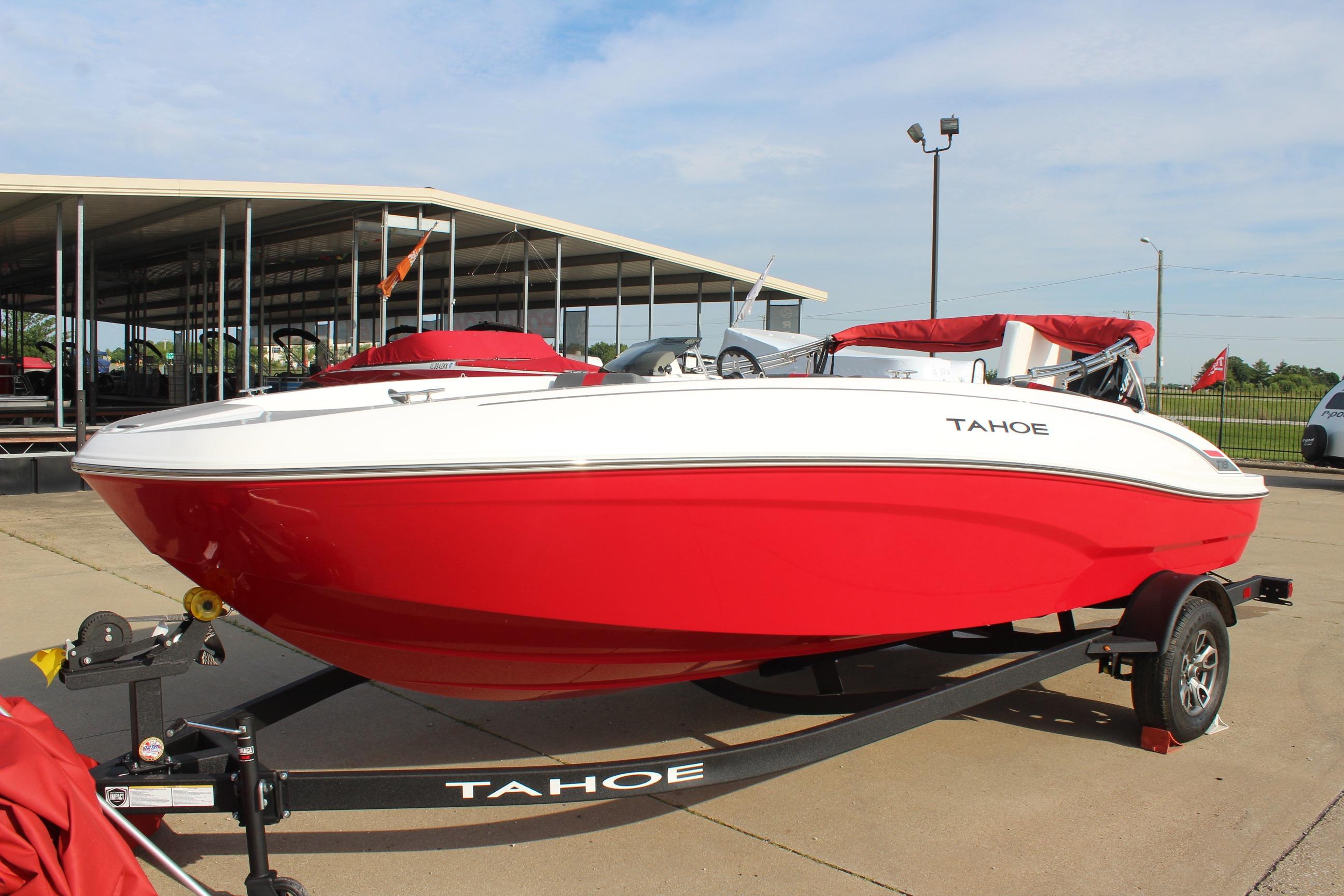 2026 Tahoe T18 boat in vibrant red on a trailer, parked outdoors.