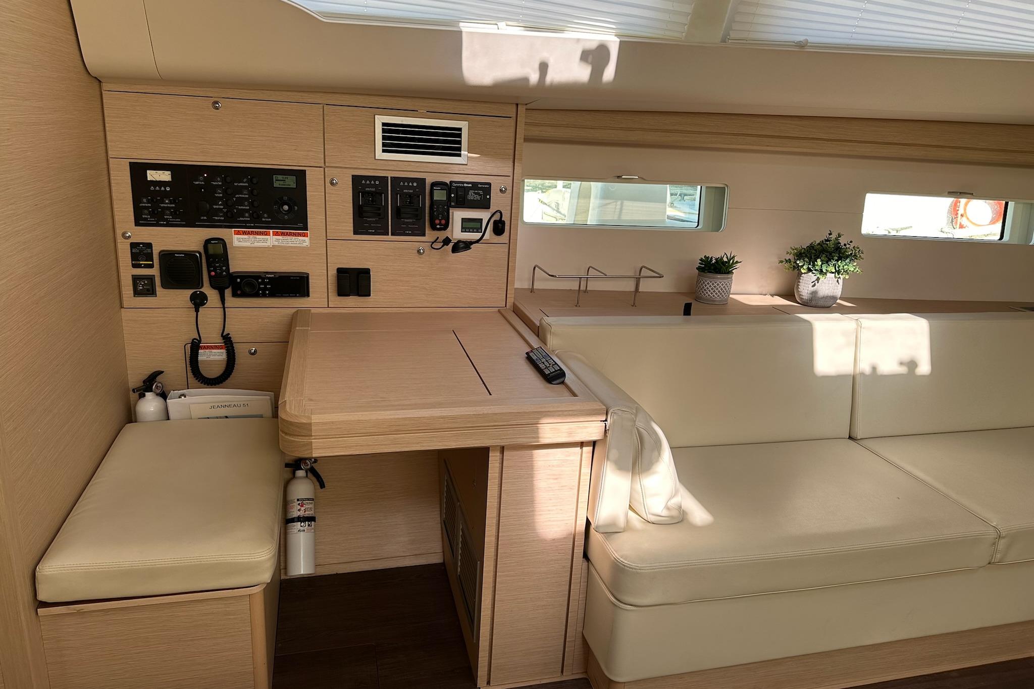 Interior of 2018 Jeanneau 51 yacht with control panel, seating, and decor.
