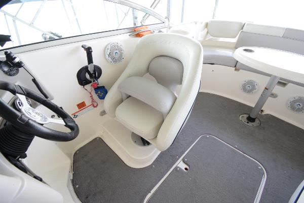 The image shows the interior of a 2010 Bryant 255 boat with a white seat and table.