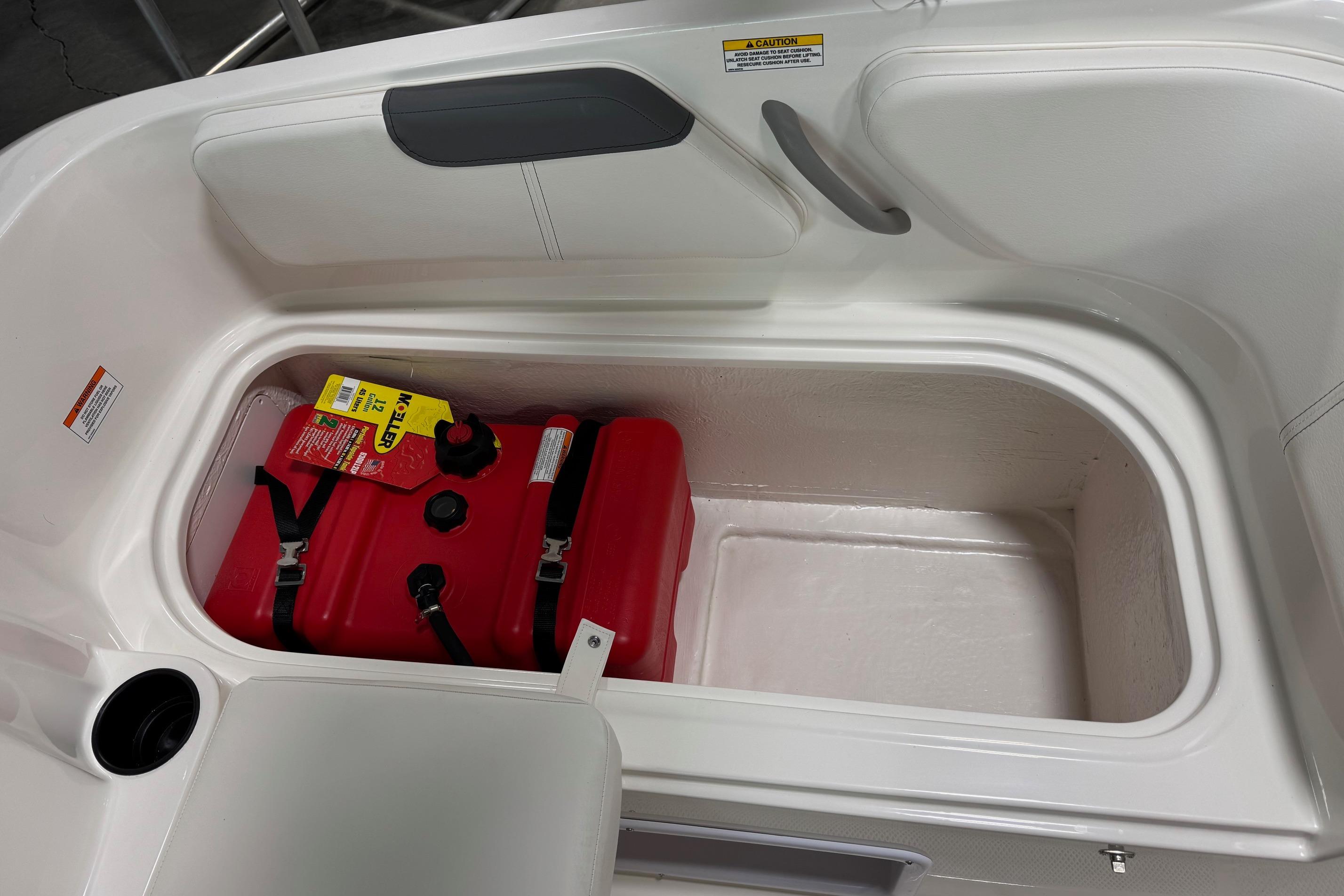 Storage compartment in 2026 Bayliner Element E18 boat with red fuel tank.