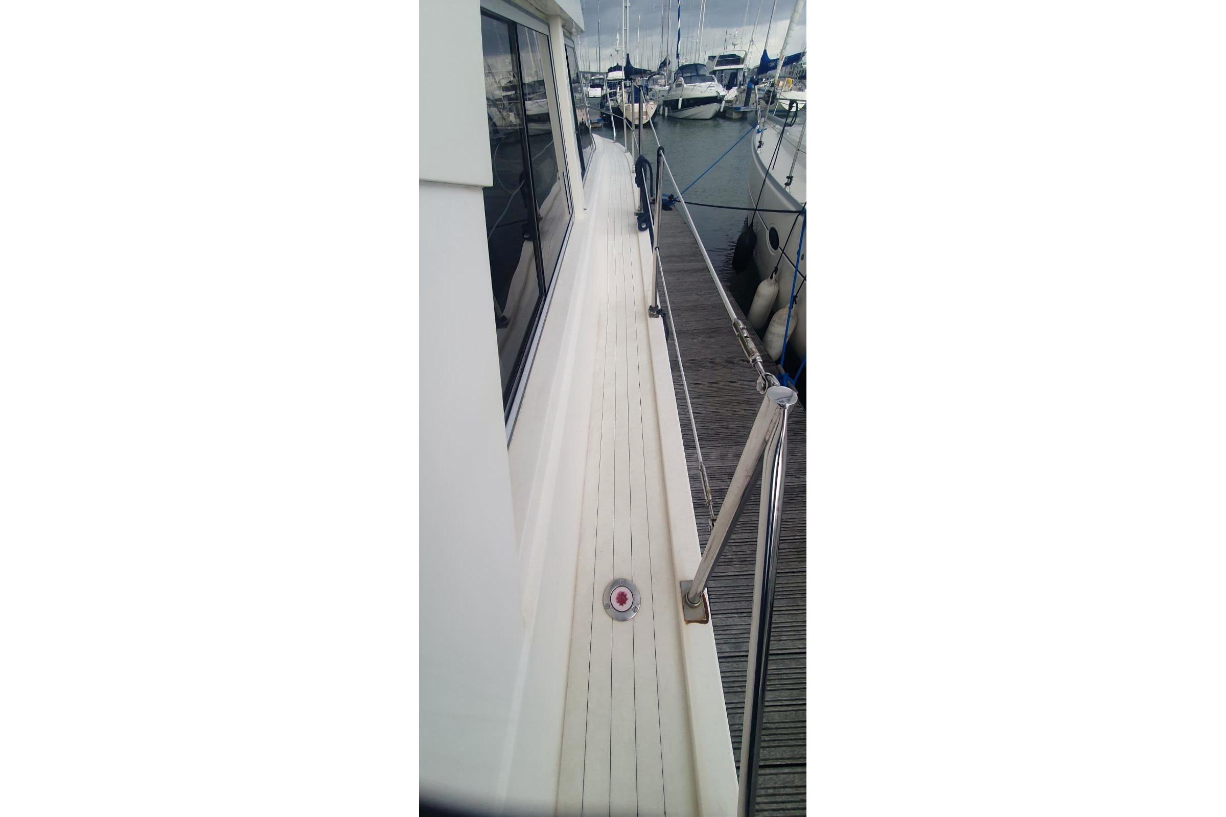 1989 Princess 35 yacht deck view at marina, showcasing sleek design and railing.
