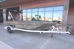 2026 Tracker Grizzly 1756 T Marsh boat in front of a building.