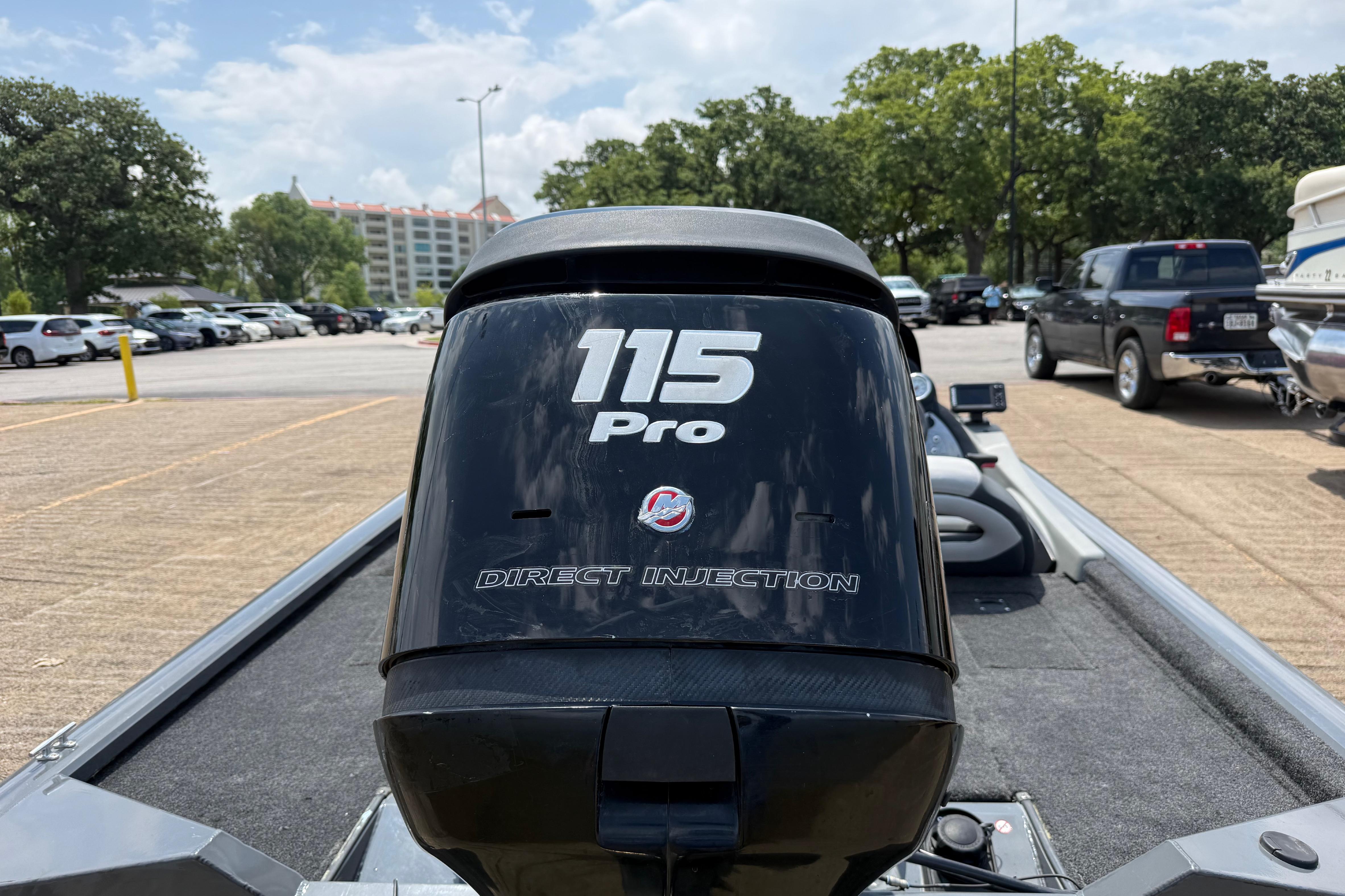 2015 Tracker Pro Team 190 TX boat with 115 Pro Direct Injection engine in parking lot.