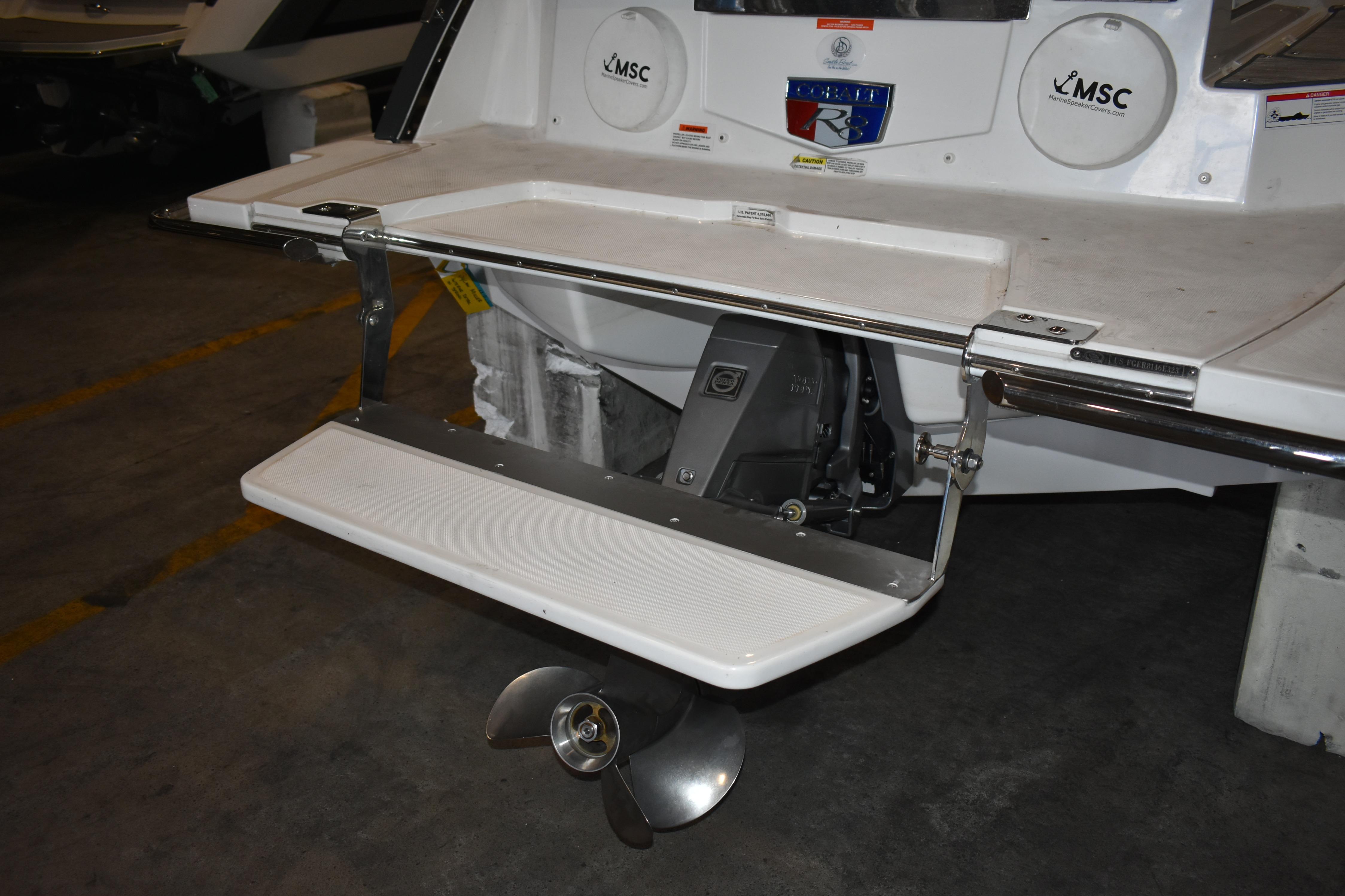 2023 Cobalt R8 boat stern with swim platform and propeller in a garage.