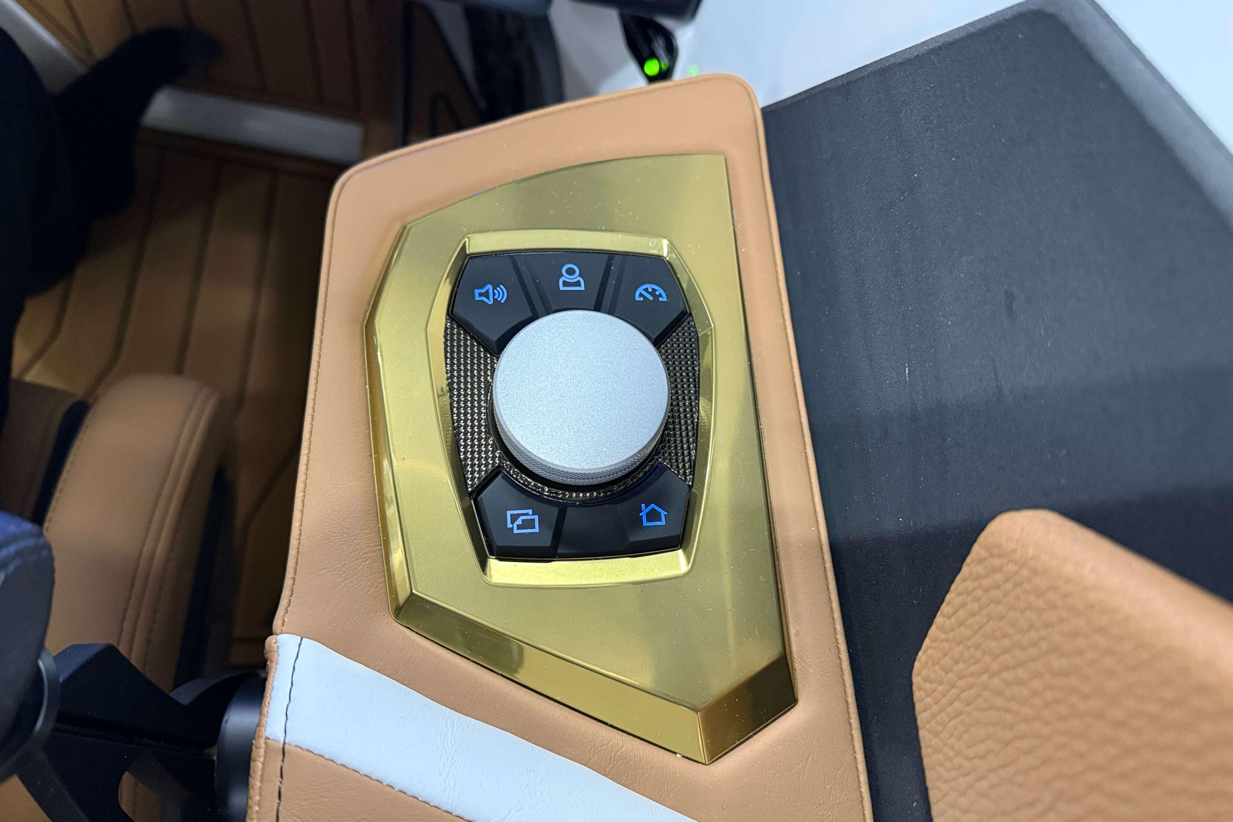Control panel of 2026 Nautique Super Air Nautique S23 boat with gold accents.
