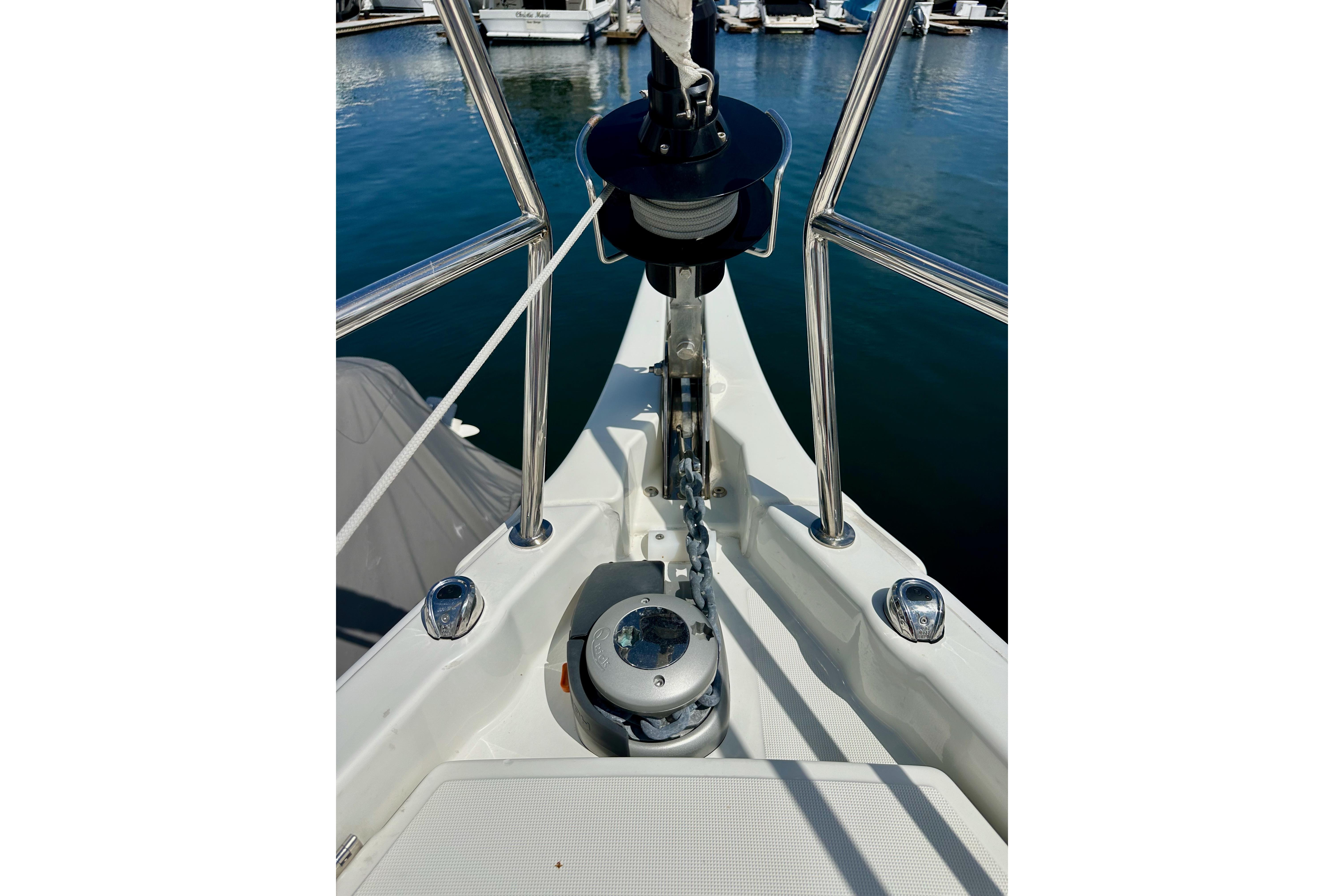 Bow of 2024 Jeanneau Sun Odyssey 410 sailboat with anchor chain and winch.