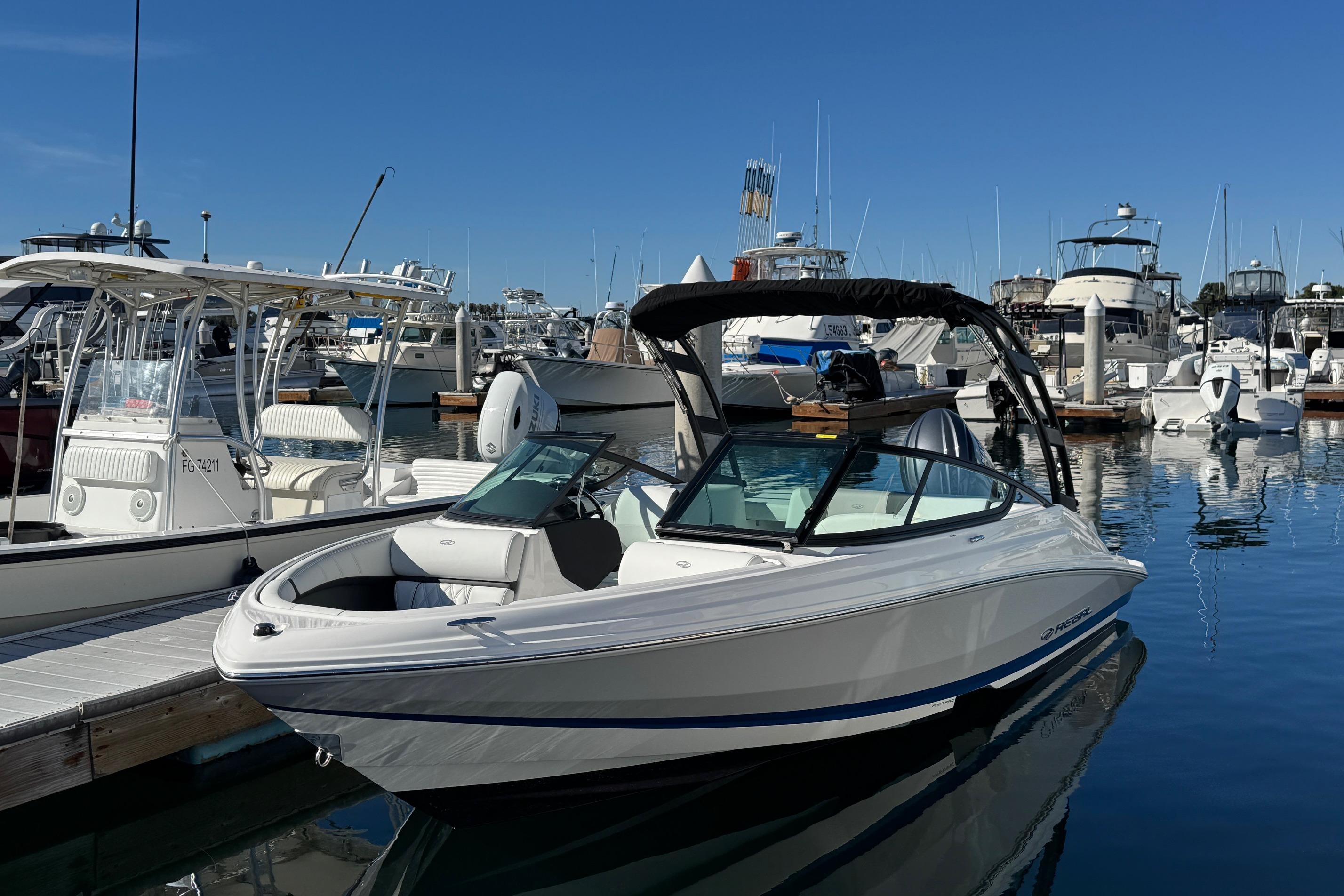 2026 Regal 21 OBX boat docked at a marina under clear blue skies.
