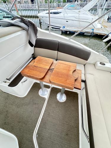 2015 Sea Ray 260 Sundancer interior with wooden table and cushioned seating.