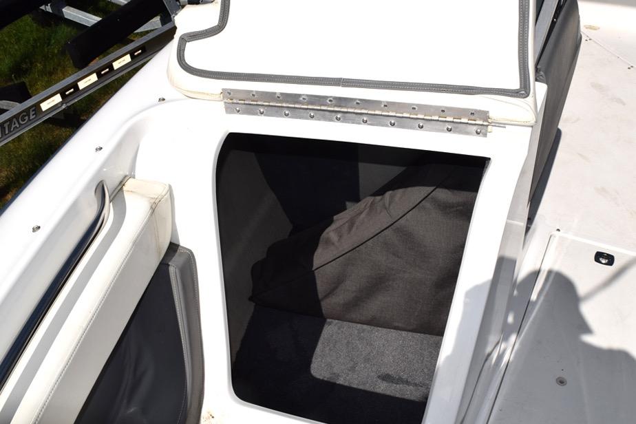 Open storage compartment on a 2006 Cobalt 240 boat, featuring white and gray interior.