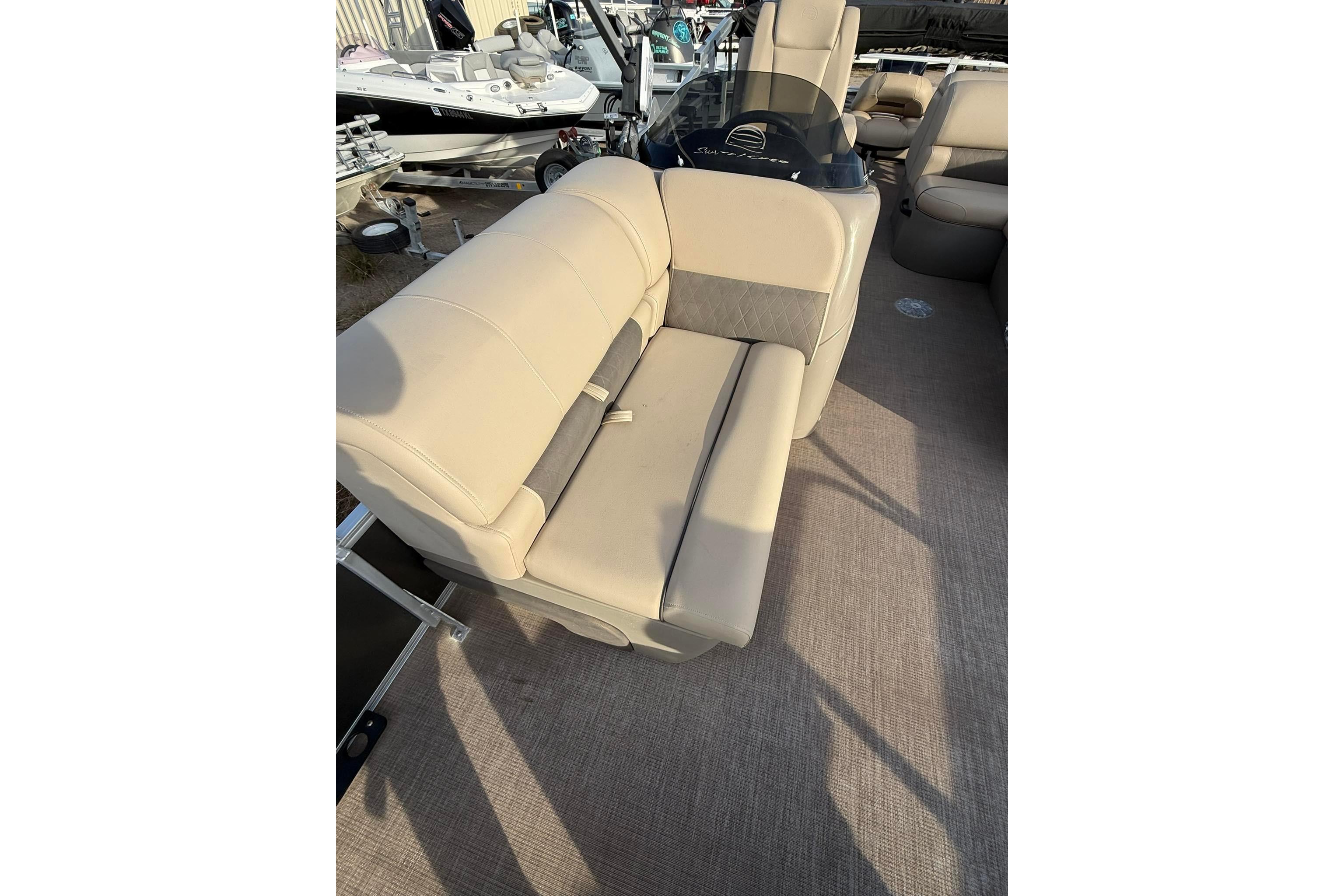 2023 Sun Tracker Fishin' Barge 22 DLX interior with beige seating and carpeted floor.