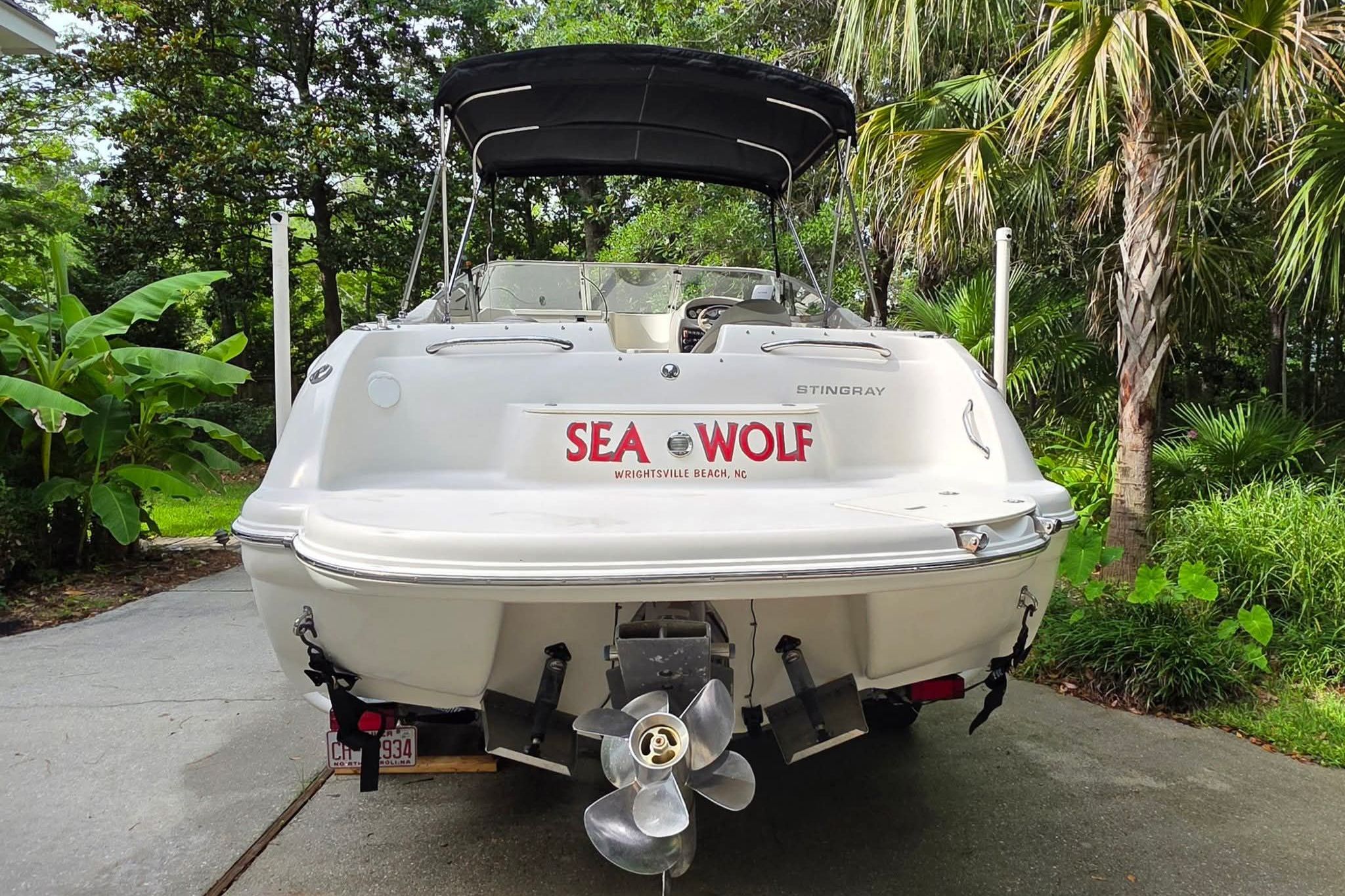 A white 2006 Stingray 250 CR on a trailer, surrounded by tropical plants.