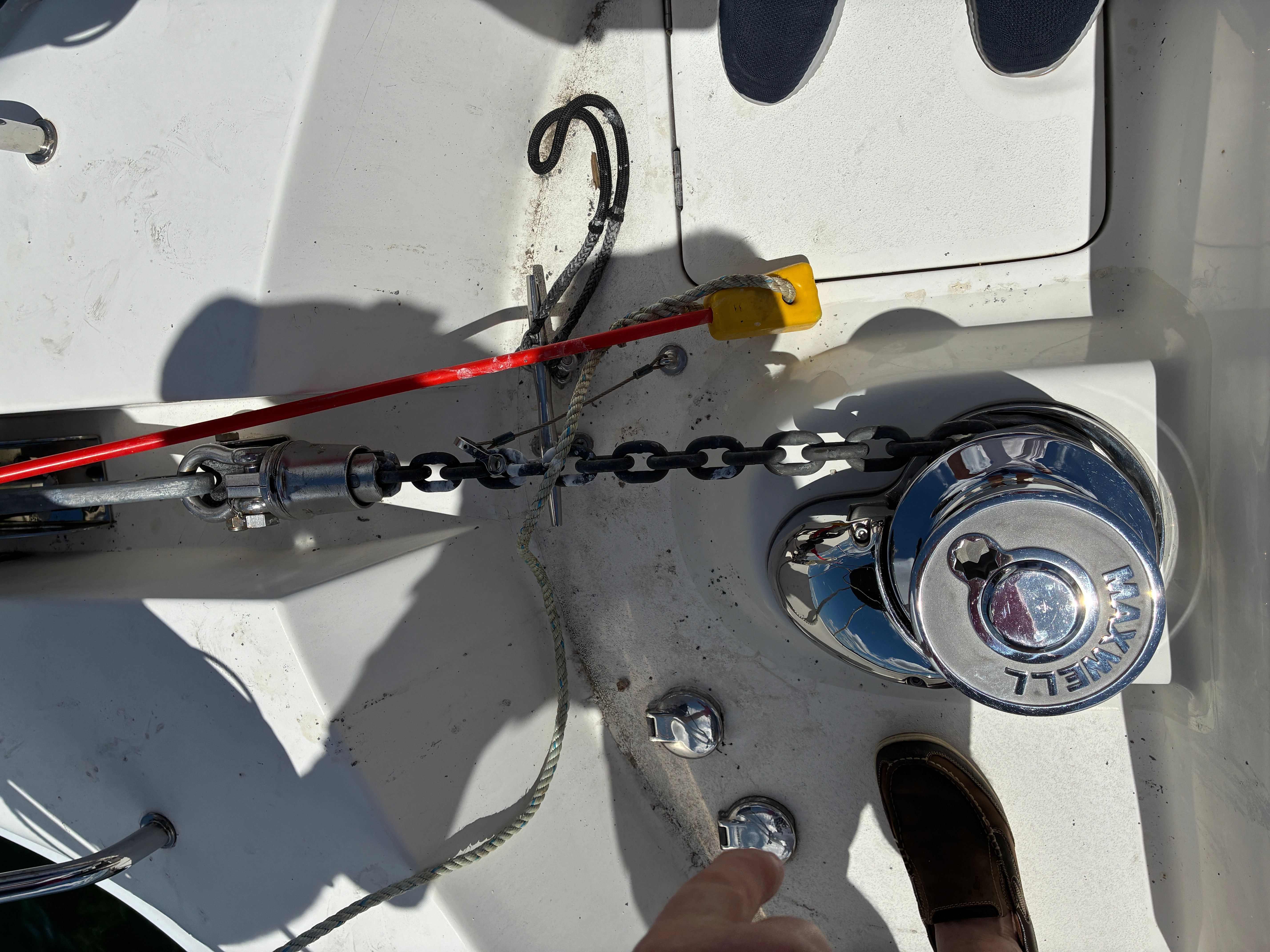 Close-up of an anchor system on a boat with chain and winch.