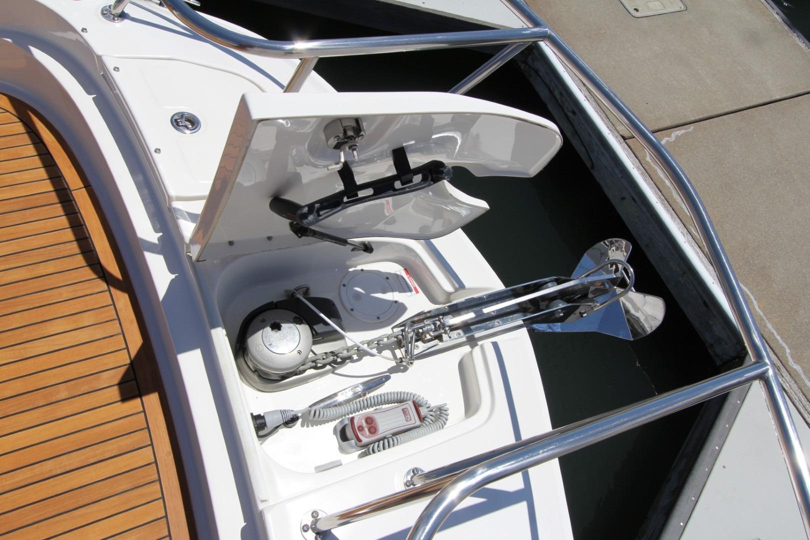 2021 Sea Ray Sundancer 320 Outboard anchor compartment with polished metal fittings and teak deck.