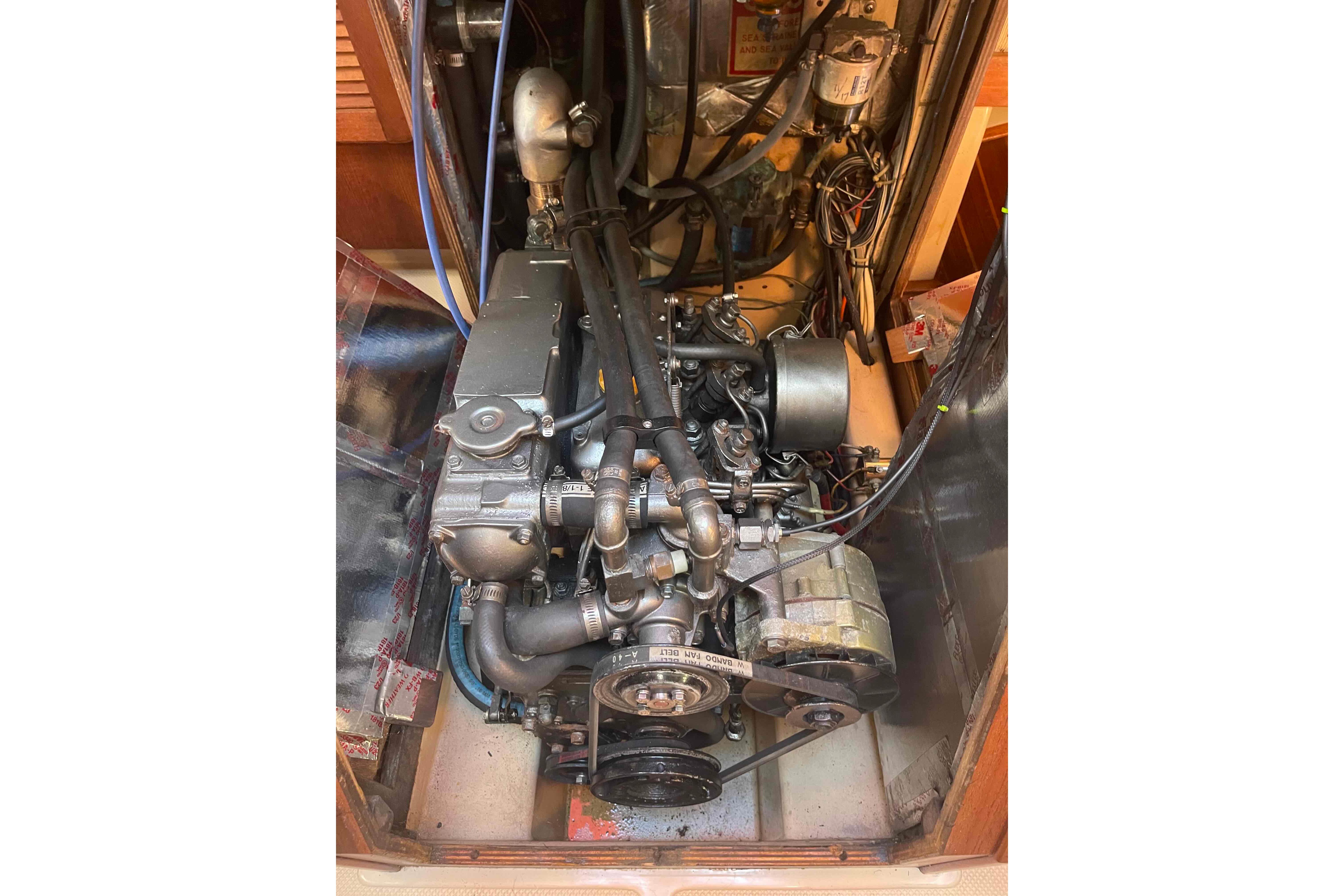 Engine compartment of a 1989 Island Packet 35 sailboat, showcasing mechanical components.