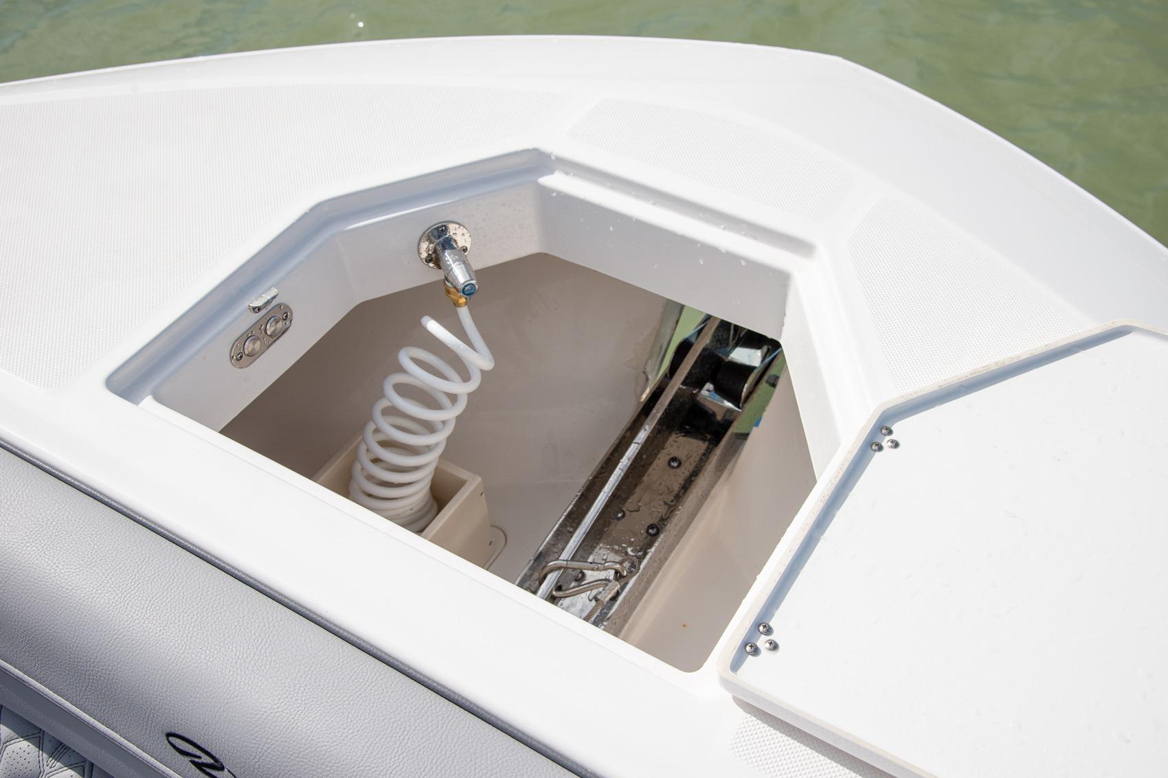 Anchor compartment of 2026 Regal LX43 boat with coiled hose and fittings.