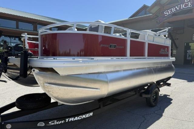 2026 Sun Tracker Bass Buggy 16 XL Select pontoon boat on trailer, parked outdoors.