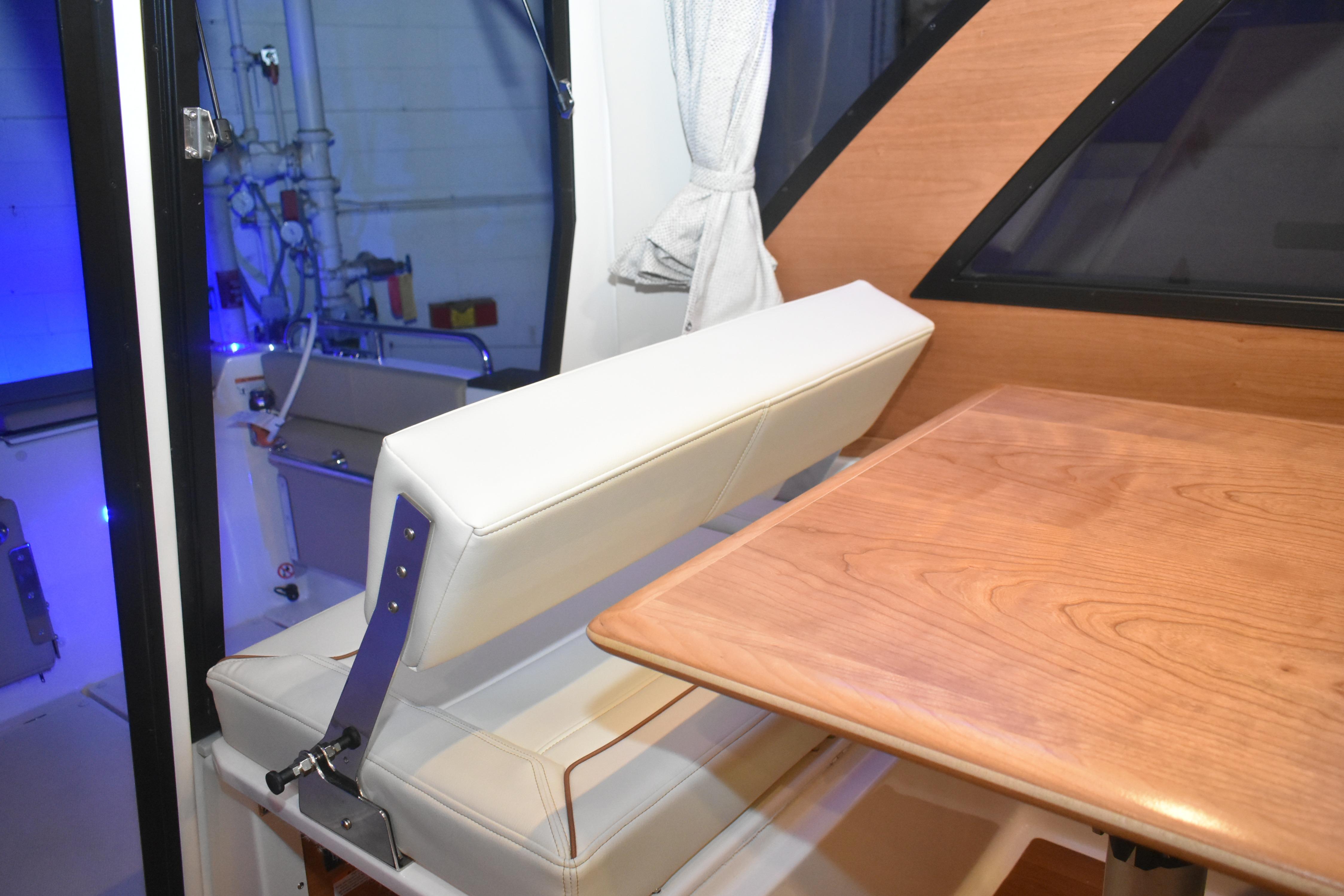 Interior of 2026 Cutwater C-248 Coupe featuring a wooden table and cushioned seating.