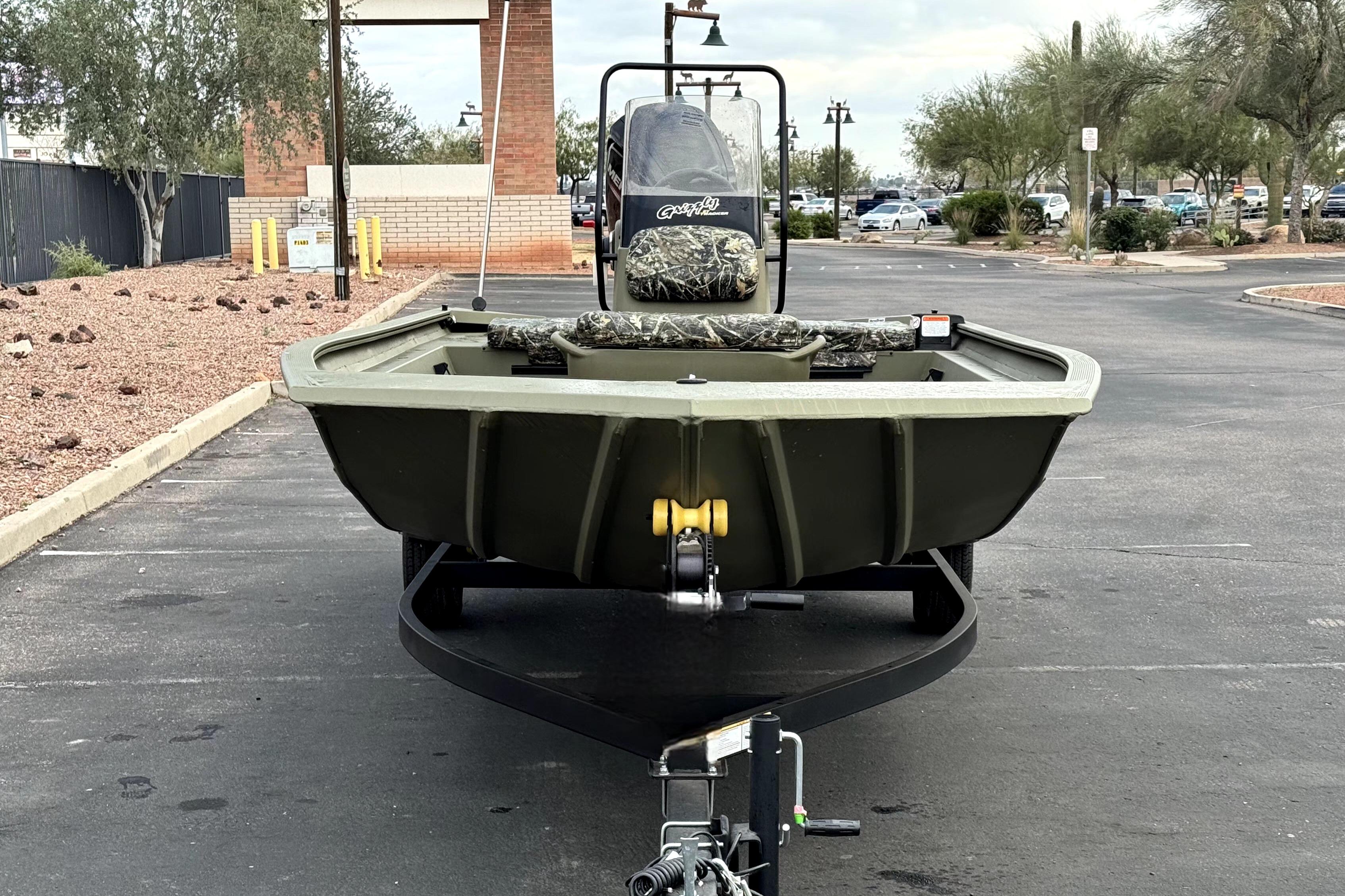 2025 Tracker Grizzly 1860 CC boat on trailer in parking lot.