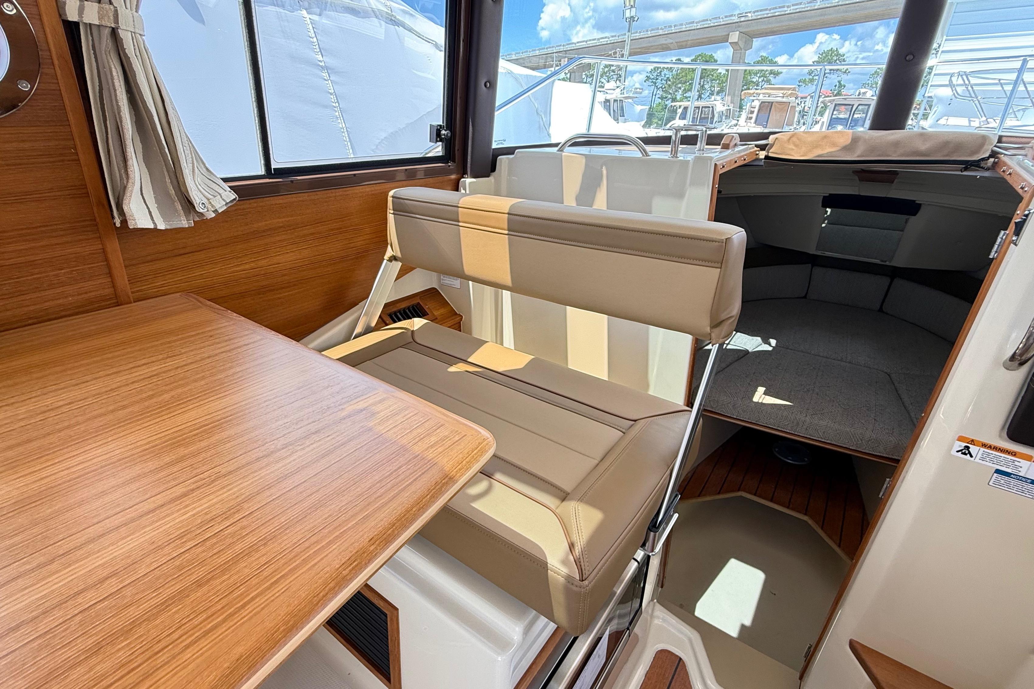2025 Ranger Tugs R-23 interior with seating, table, and cabin view.