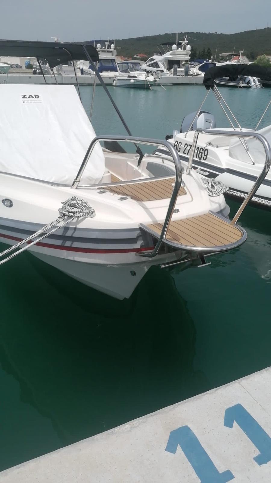 2020 Zar 85 SL boat docked in marina, featuring sleek design and wooden deck.