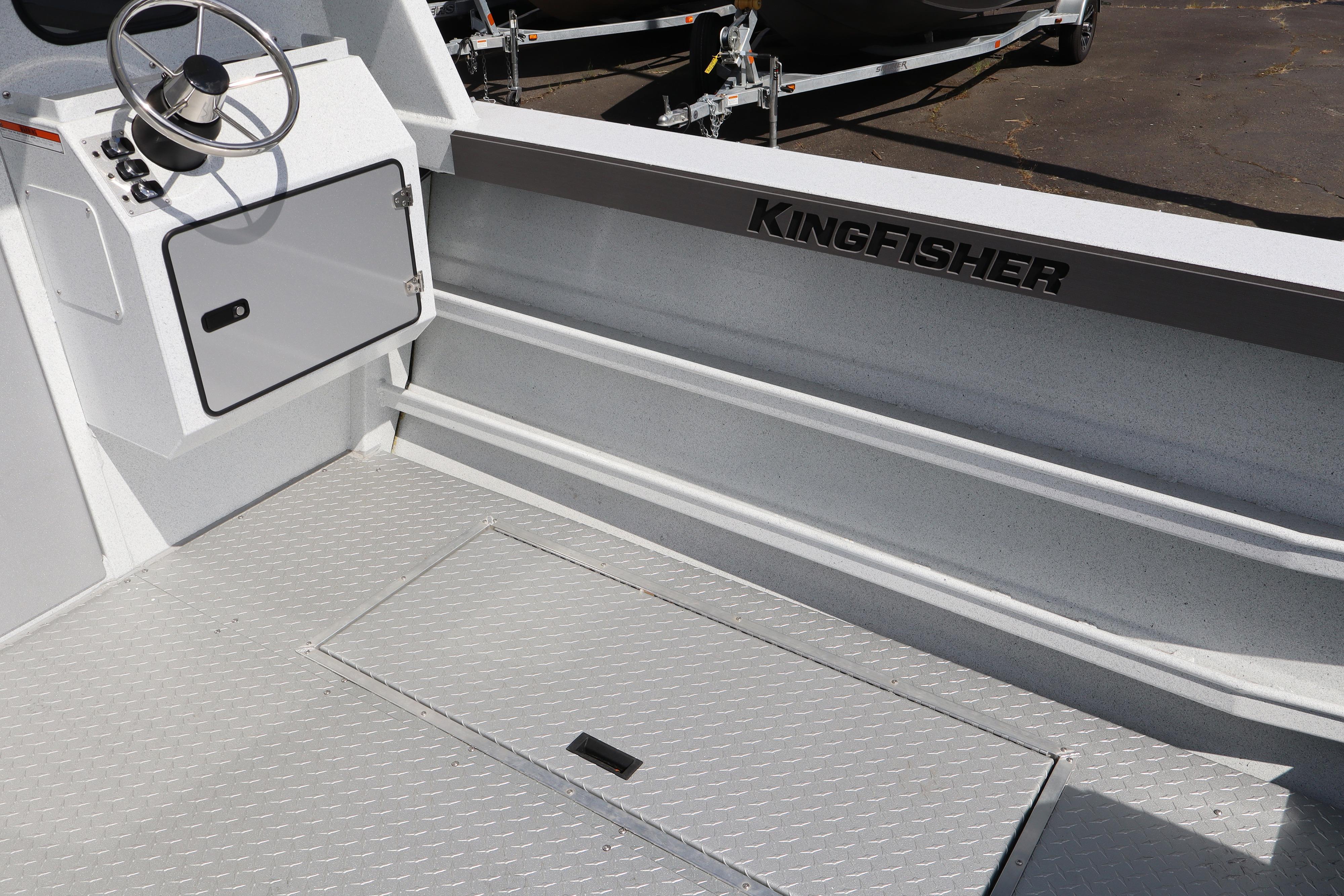 Interior of 2026 KingFisher 2425 Escape HT boat, featuring steering console and storage hatch.