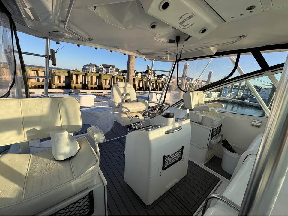 The image shows the cockpit of a 2005 Luhrs 32 Open with white seats and a helm station.