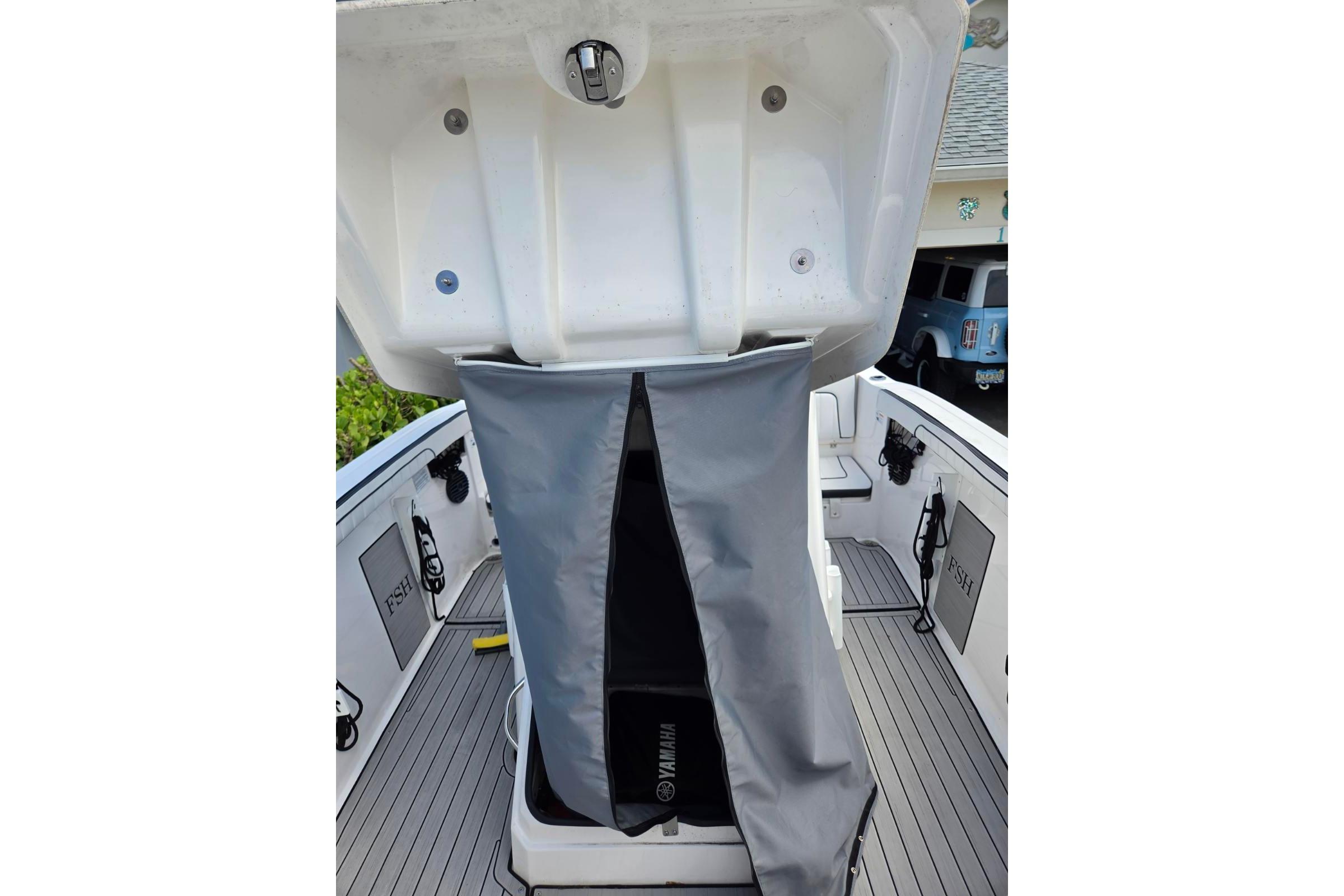 2024 Yamaha Boats 222 FSH Sport E interior with open storage compartment and gray cover.