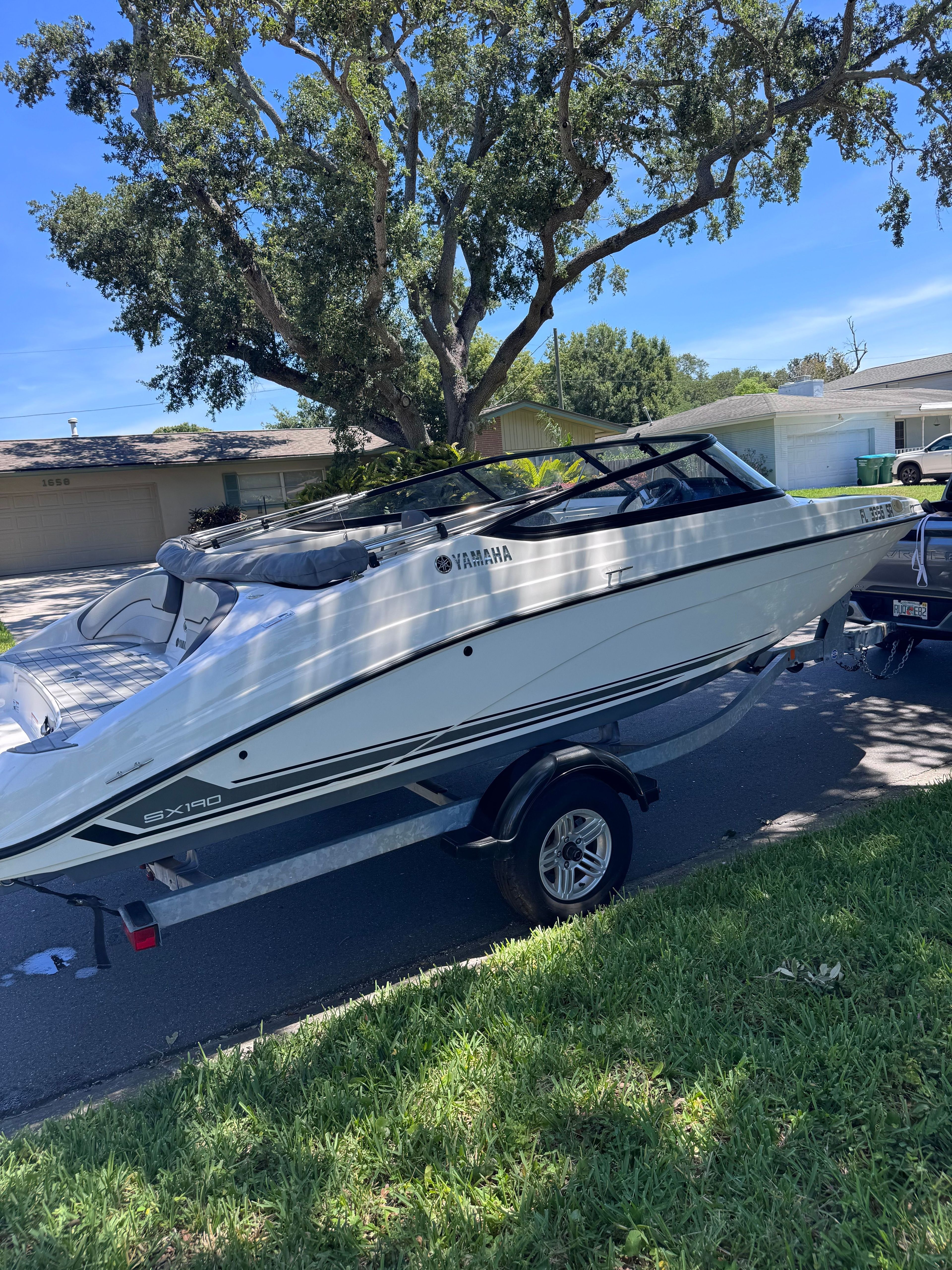 2020 Yamaha SX190 boat on trailer under tree.