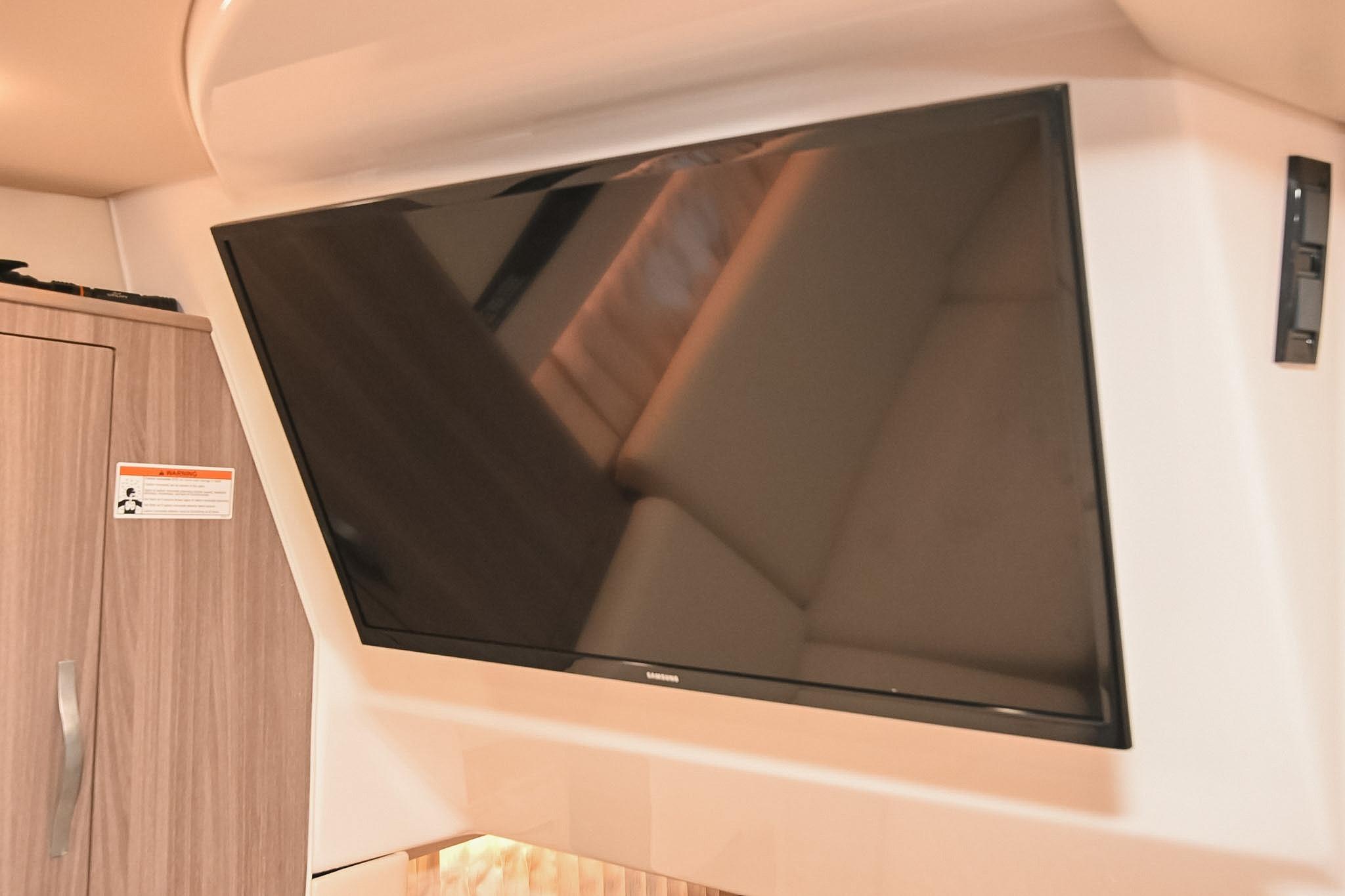 Flat-screen TV in 2021 Regal 33 Express cabin interior.