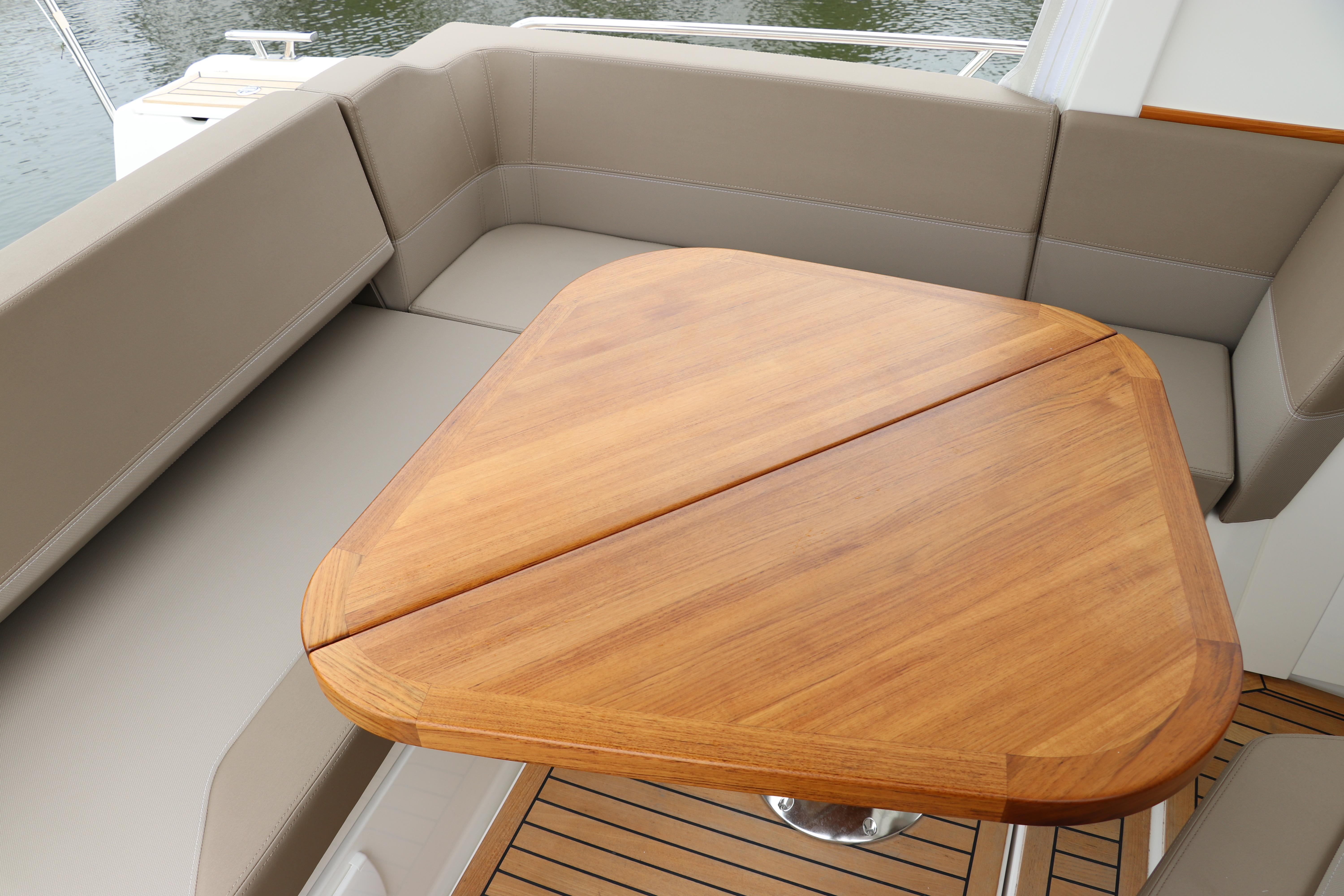 Luxurious seating area on 2024 Nimbus Weekender 9 with wooden table.