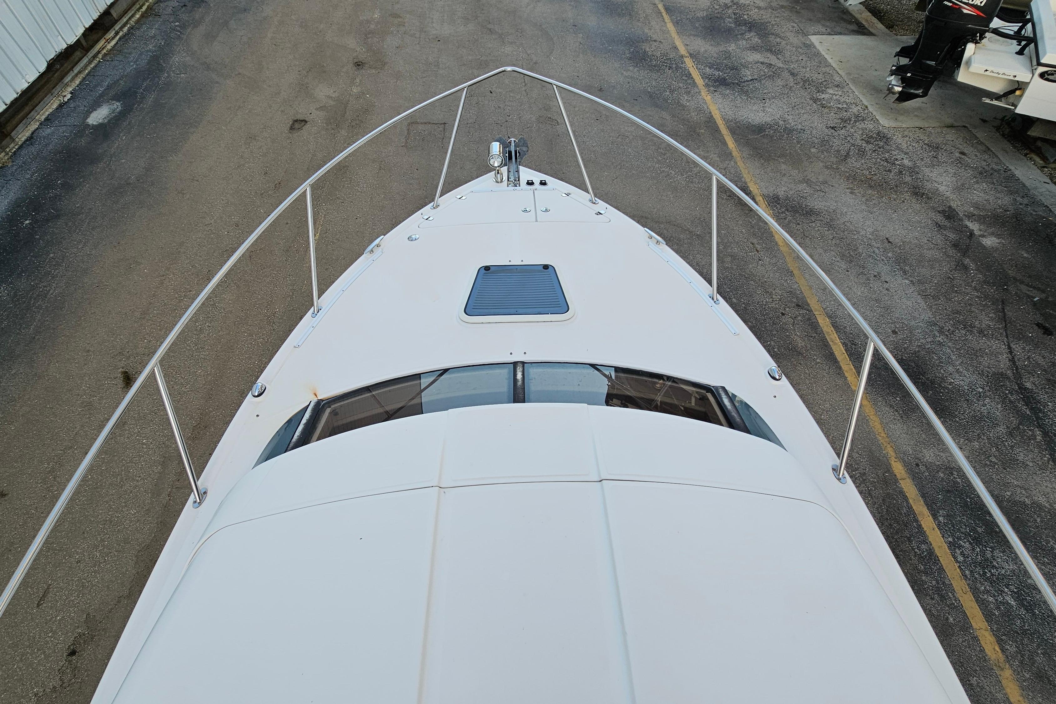 2005 Regal 3060 Window Express boat, top view, docked on pavement.