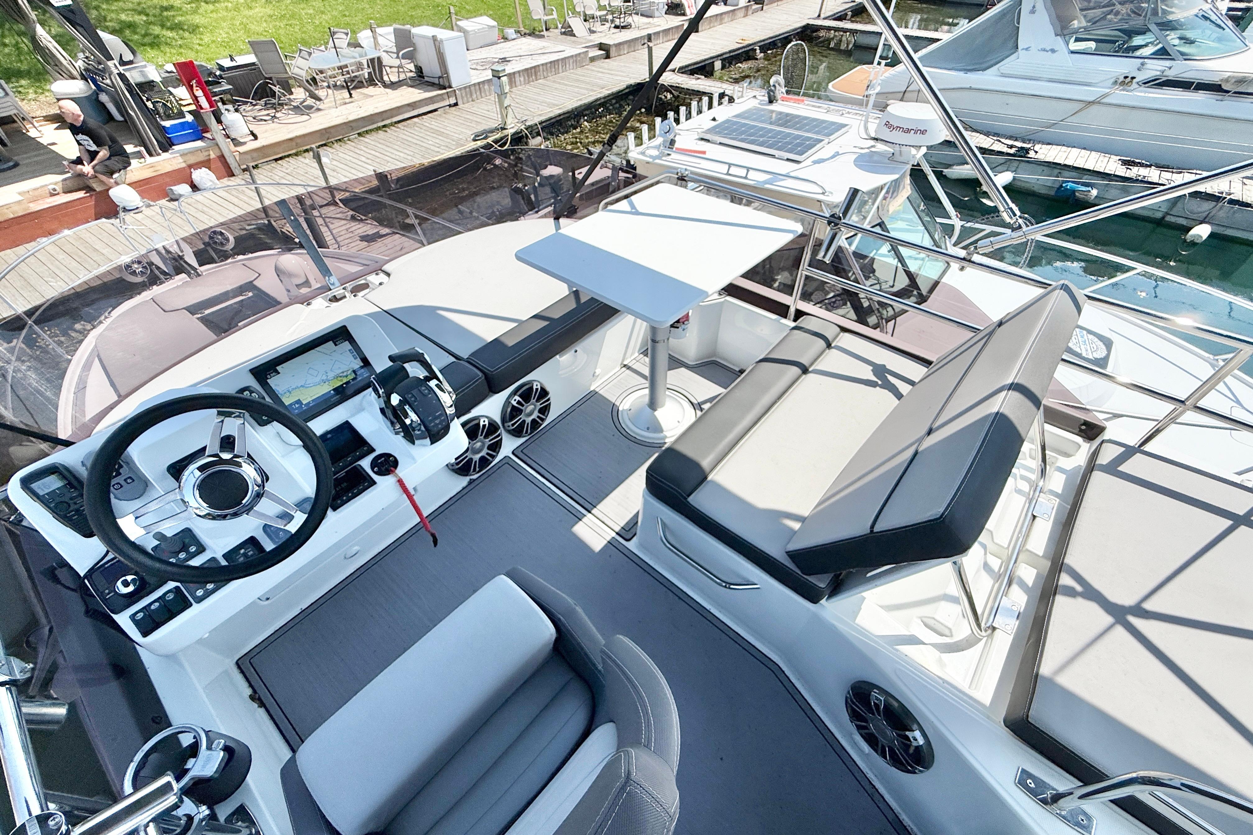 Flybridge of 2022 Jeanneau NC 1095 Fly with helm, seating, and table.