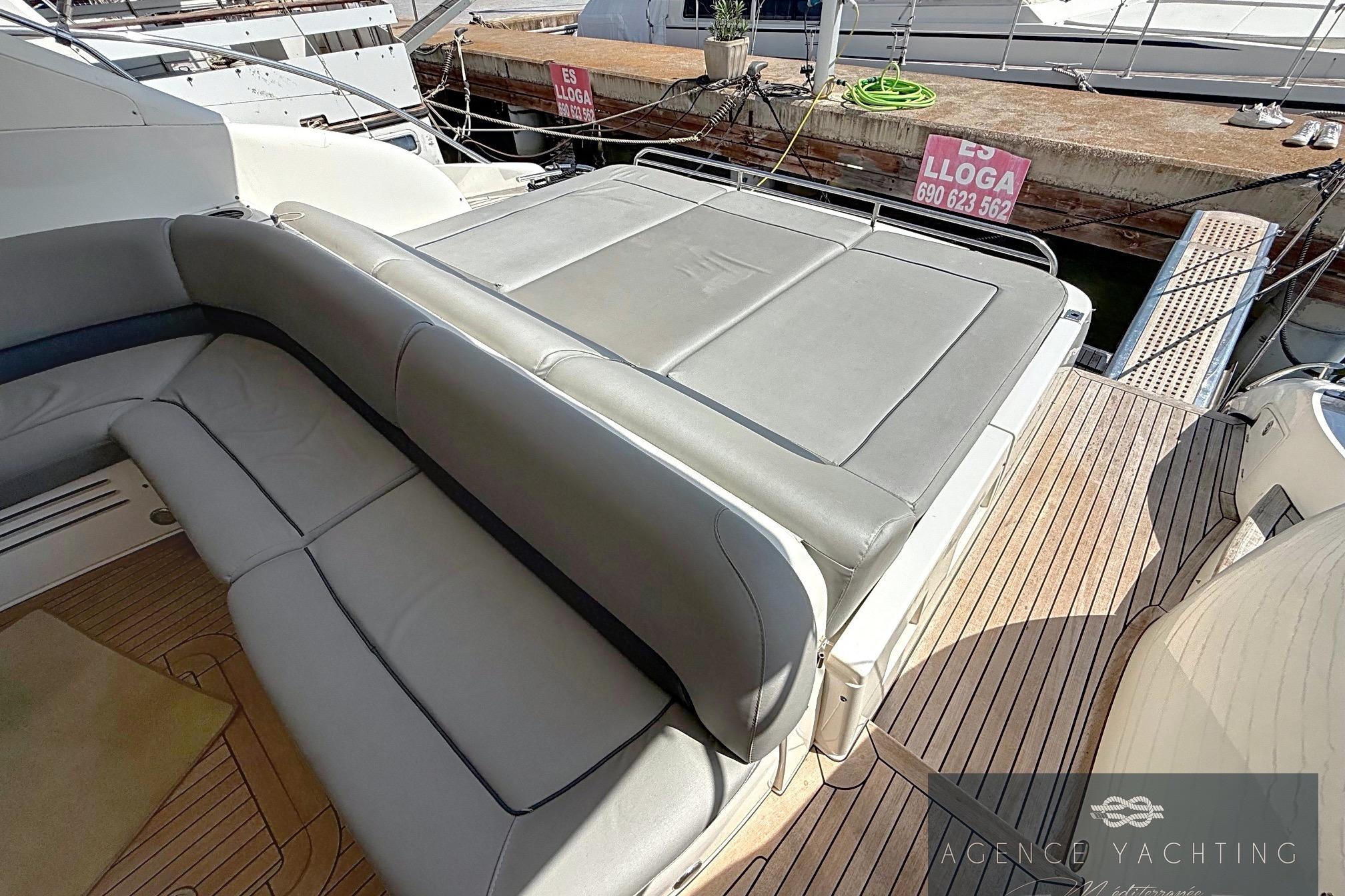 Luxury seating area on 2004 Princess V58 yacht, docked at marina.