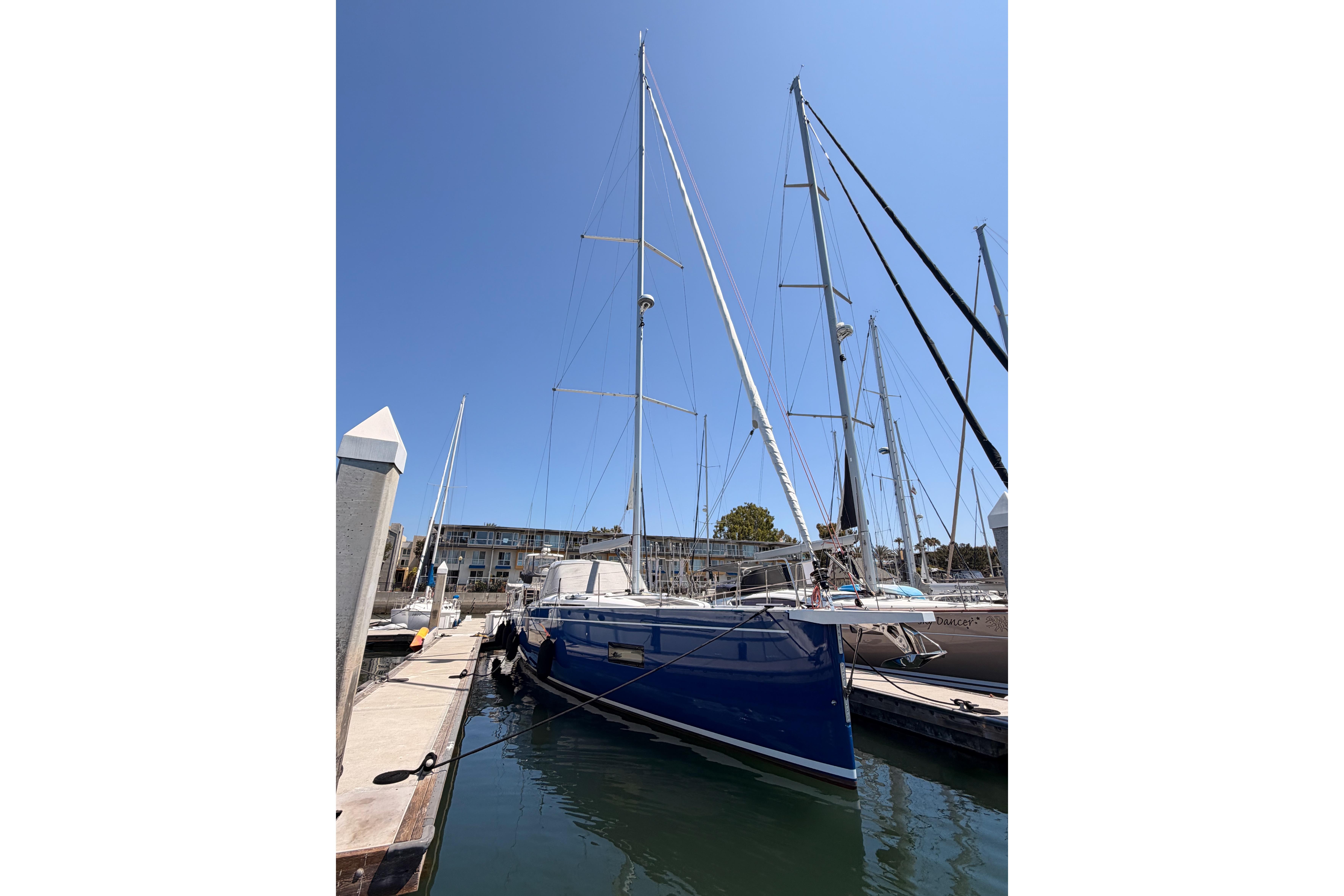 2022 Beneteau Oceanis Yacht 54 docked at marina under clear blue sky.