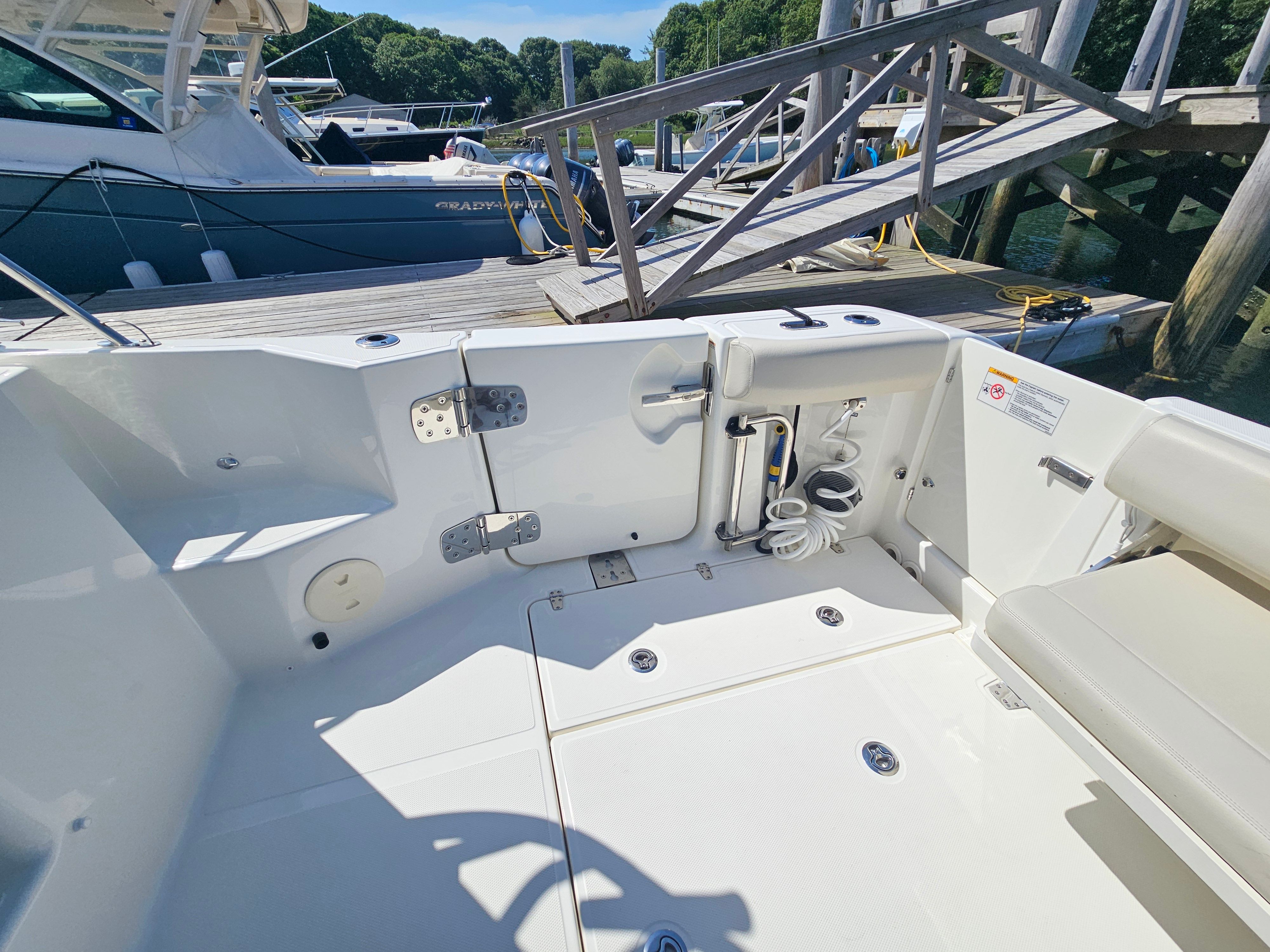 The image shows the cockpit of a Boston Whaler 325 Conquest docked at a pier.