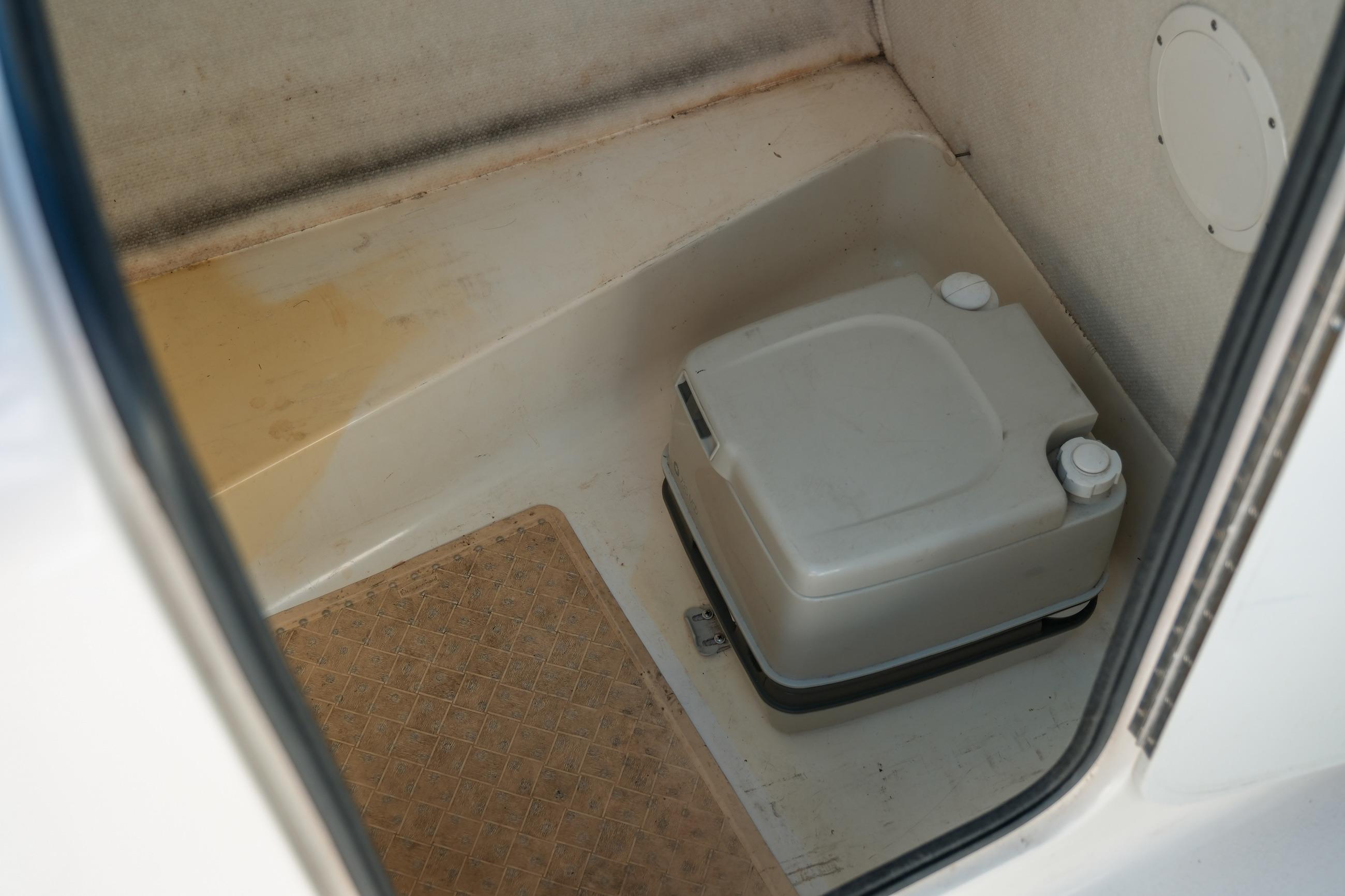 Portable toilet inside 1998 Chaparral 232 Sunesta boat compartment.