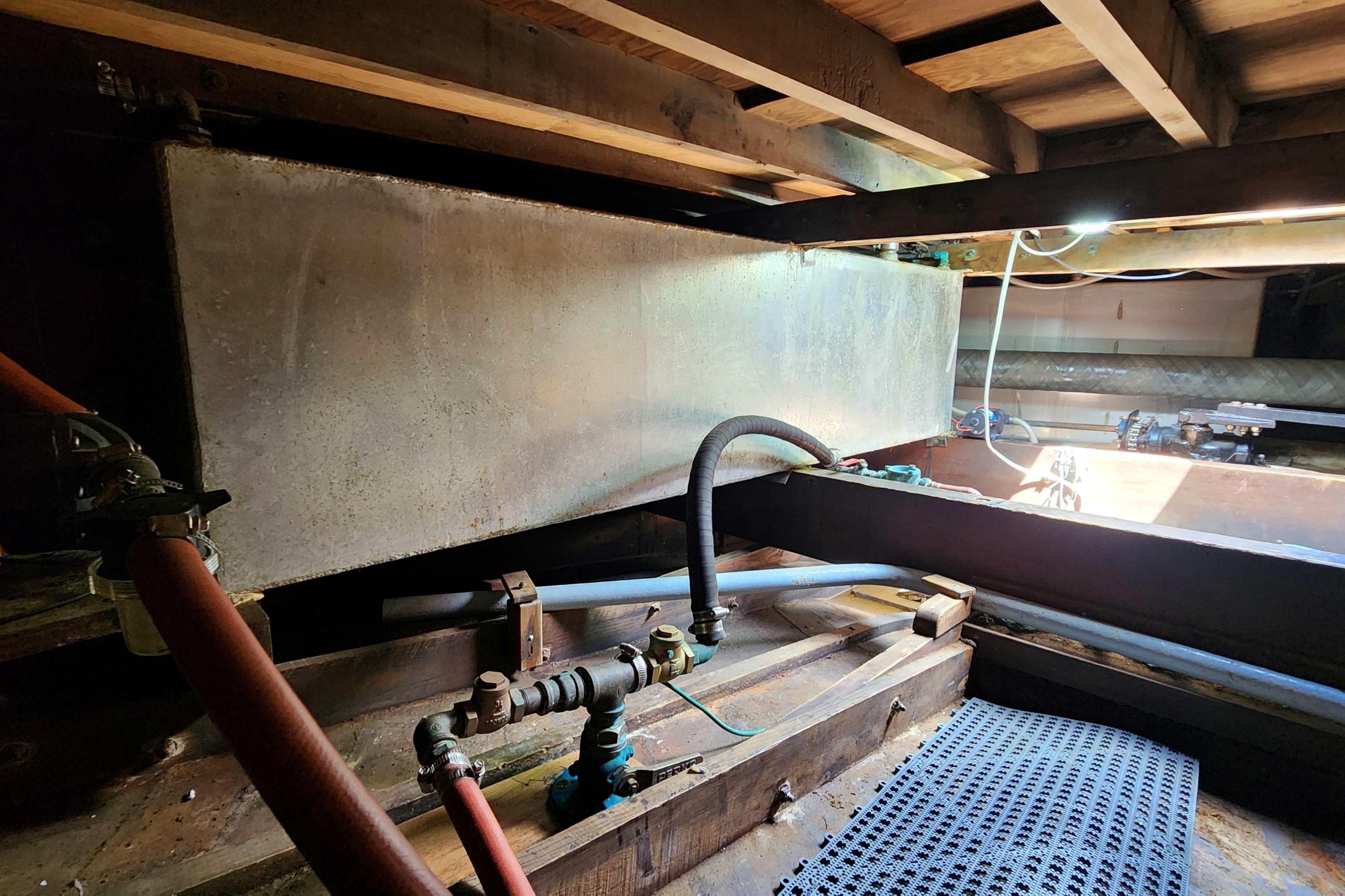 Interior view of a 1964 Grandy Tour Boat showing mechanical components and piping.