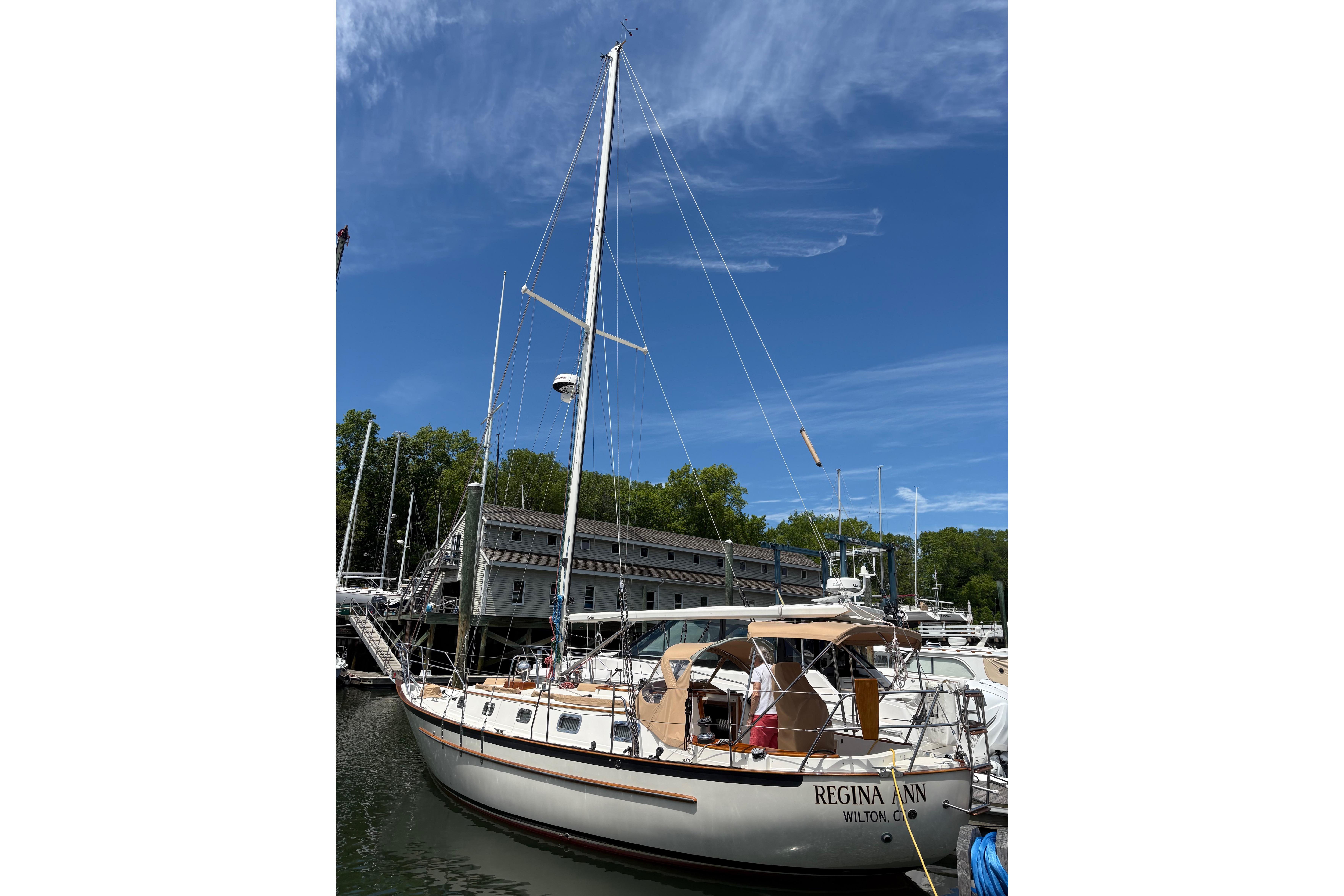 Sailboat docked at marina, Pacific Seacraft Crealock 34, 1997 model, under clear blue sky.