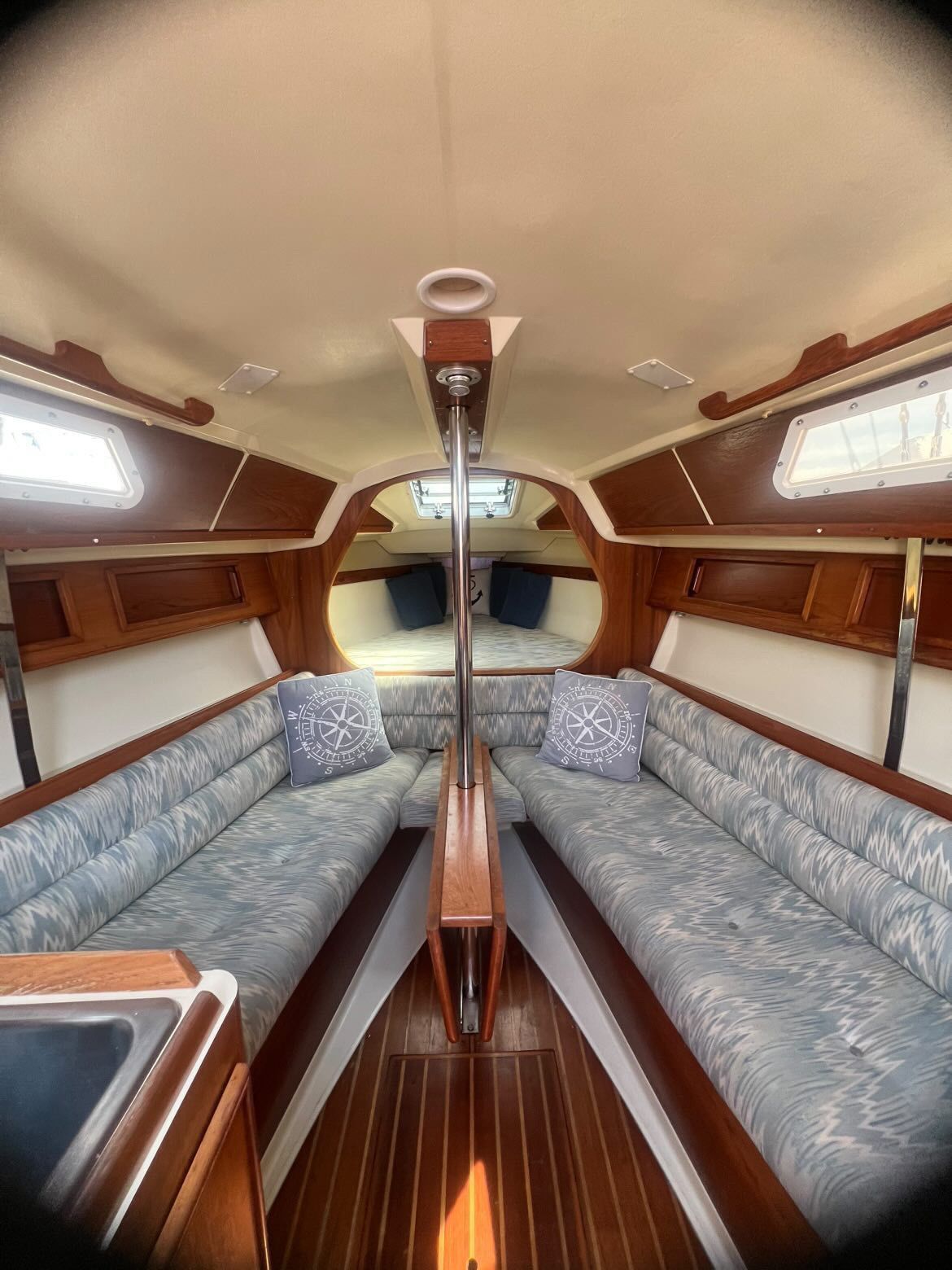 Interior of a 1988 Pearson 28 sailboat with cozy seating and wood finishes.