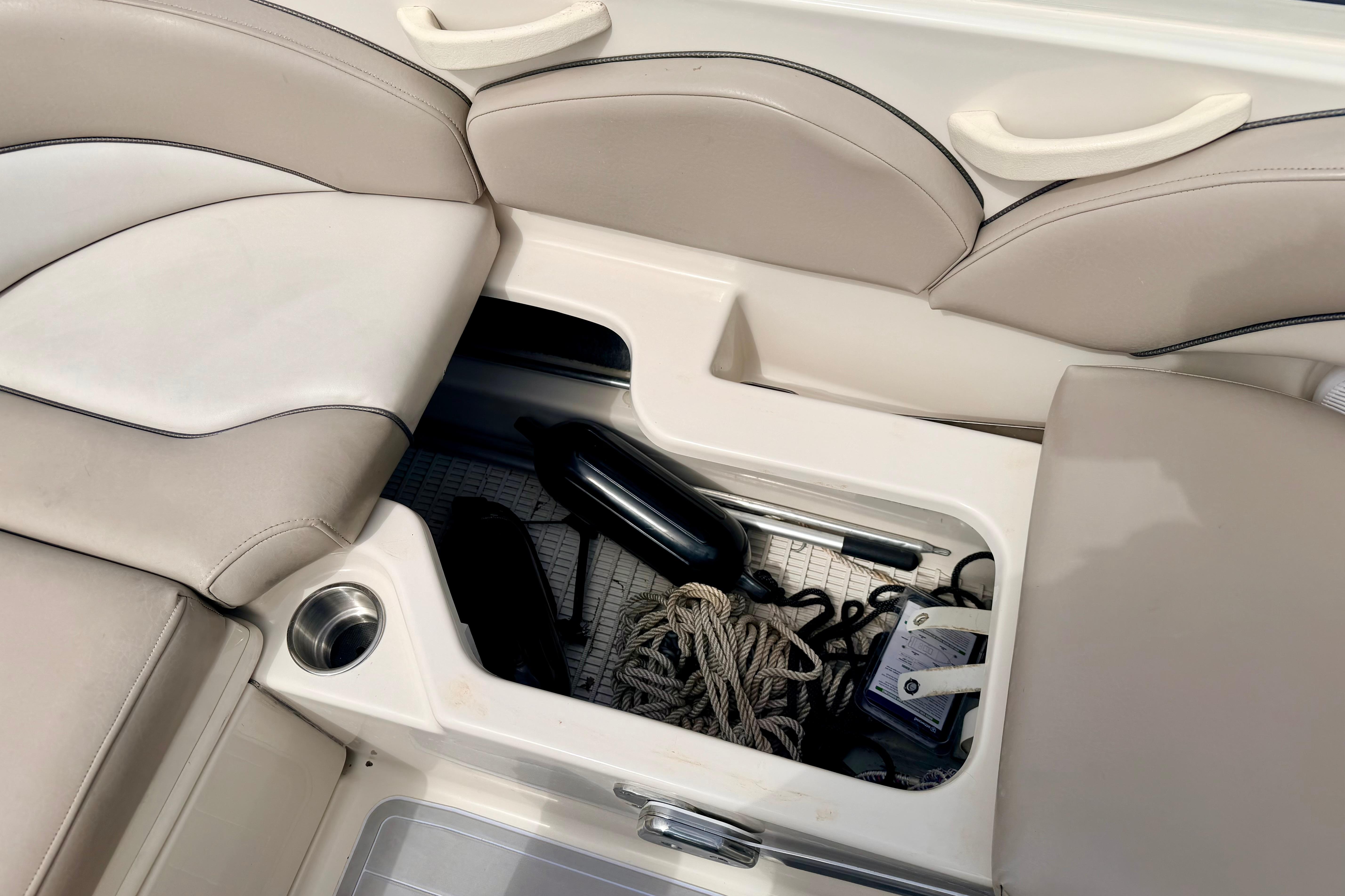 Storage compartment on a 2003 Sea Ray 200 Sundeck boat with ropes and accessories.